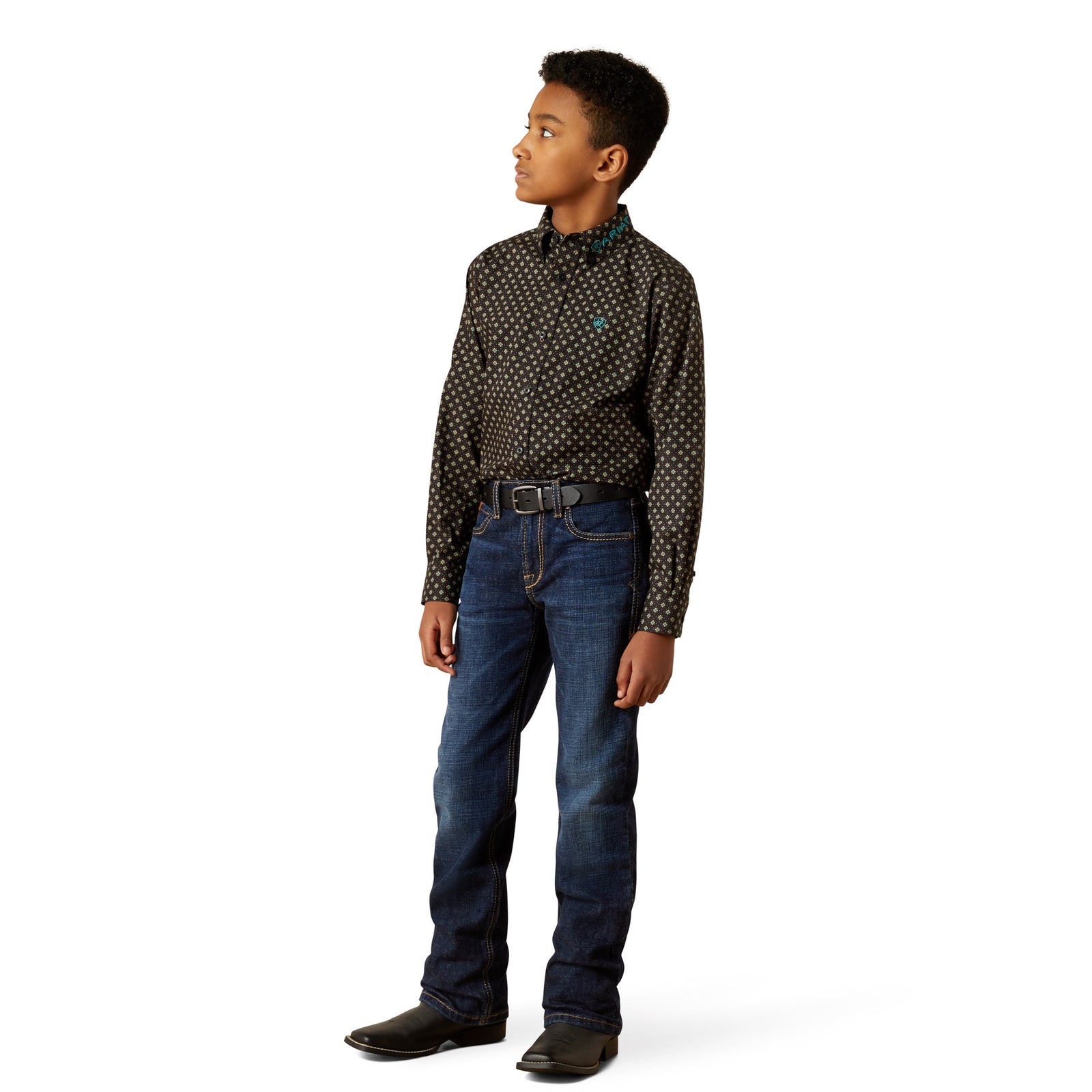 Young boy wearing a patterned shirt and jeans on a white background