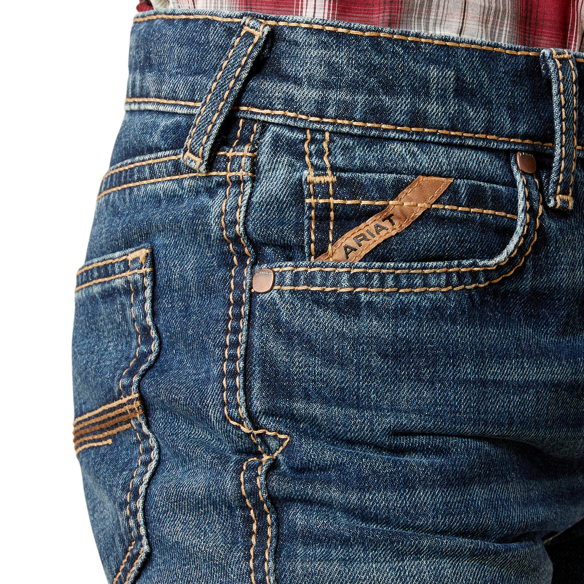 Close-up of blue jeans with ARIAT branding on a white background