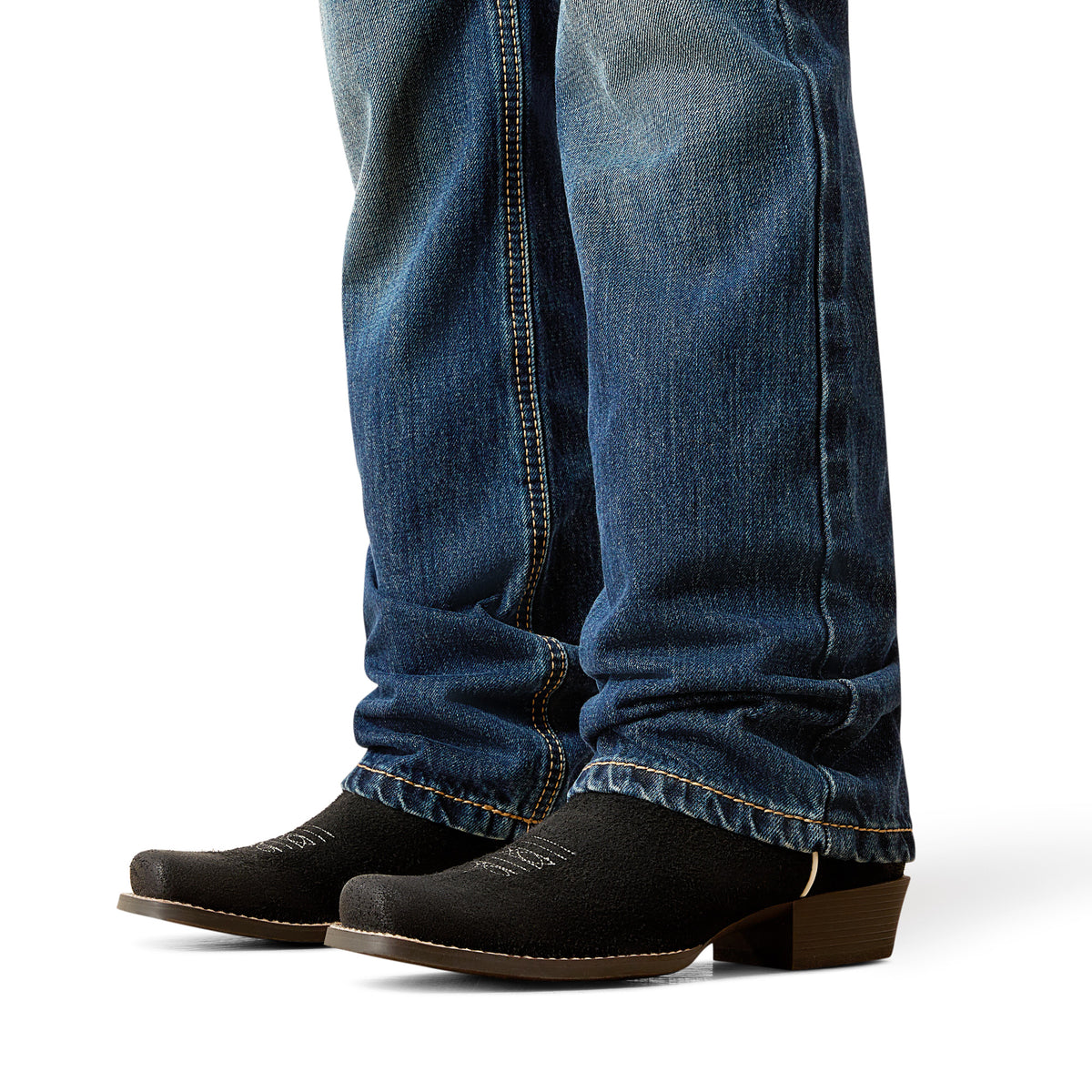 Close-up of blue jeans and black boots on a white background