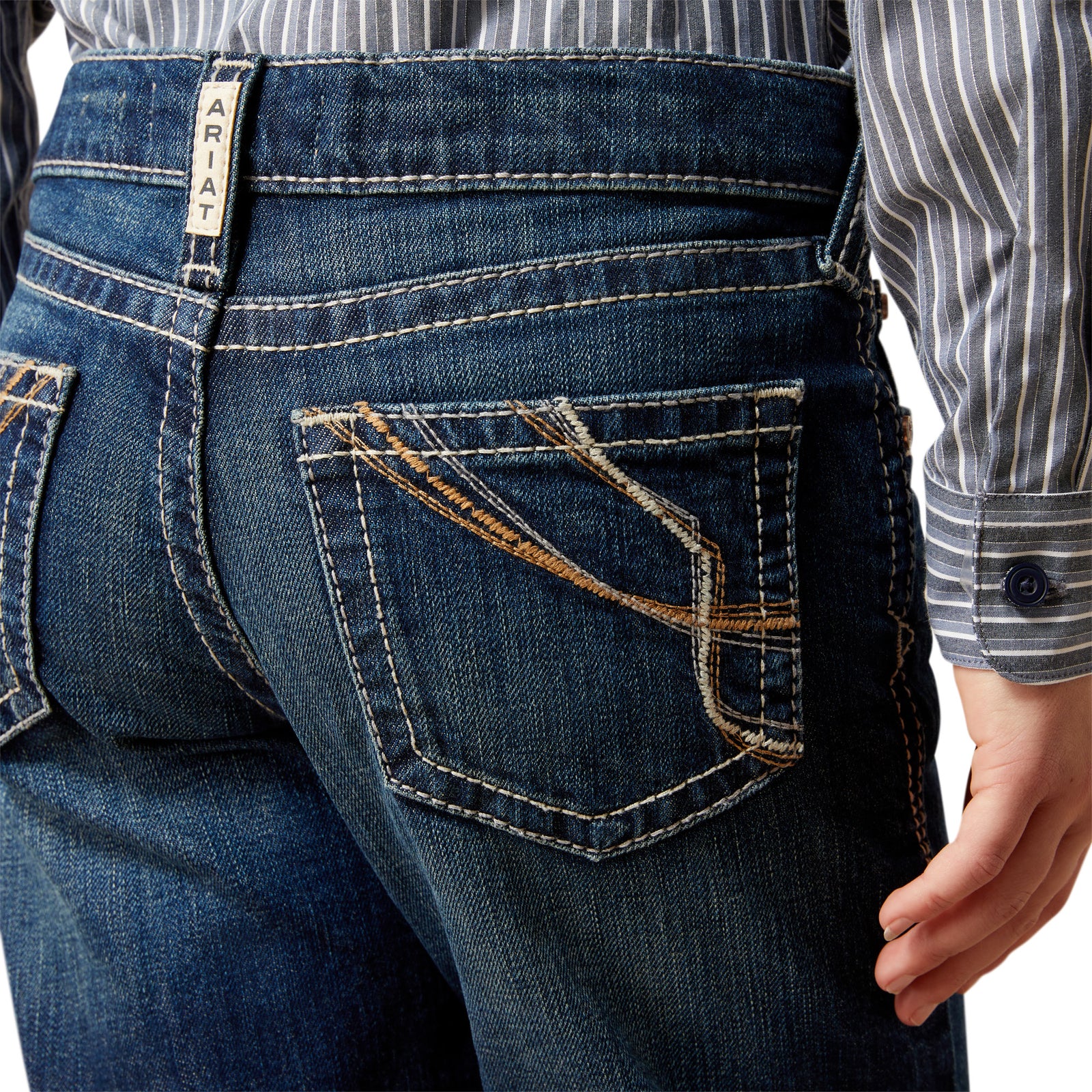 Close-up of blue jeans with a visible brand label on a white background