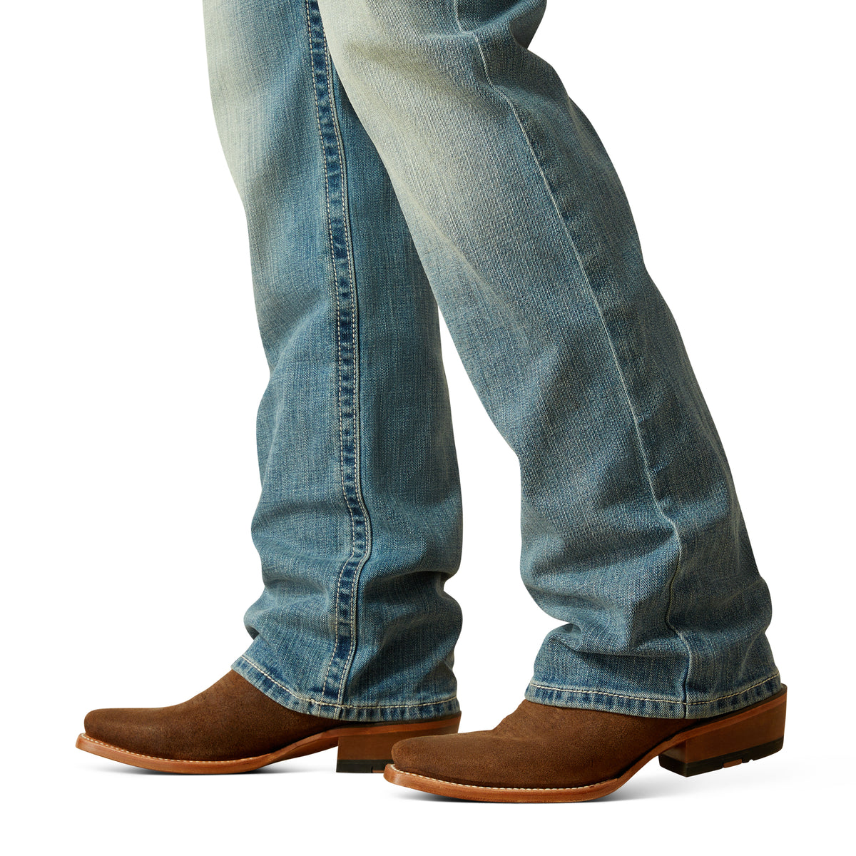 Ariat Men's M4 Thomas Relaxed Boot Cut Jean. Close-up of blue jeans and brown cowboy boots on a white background