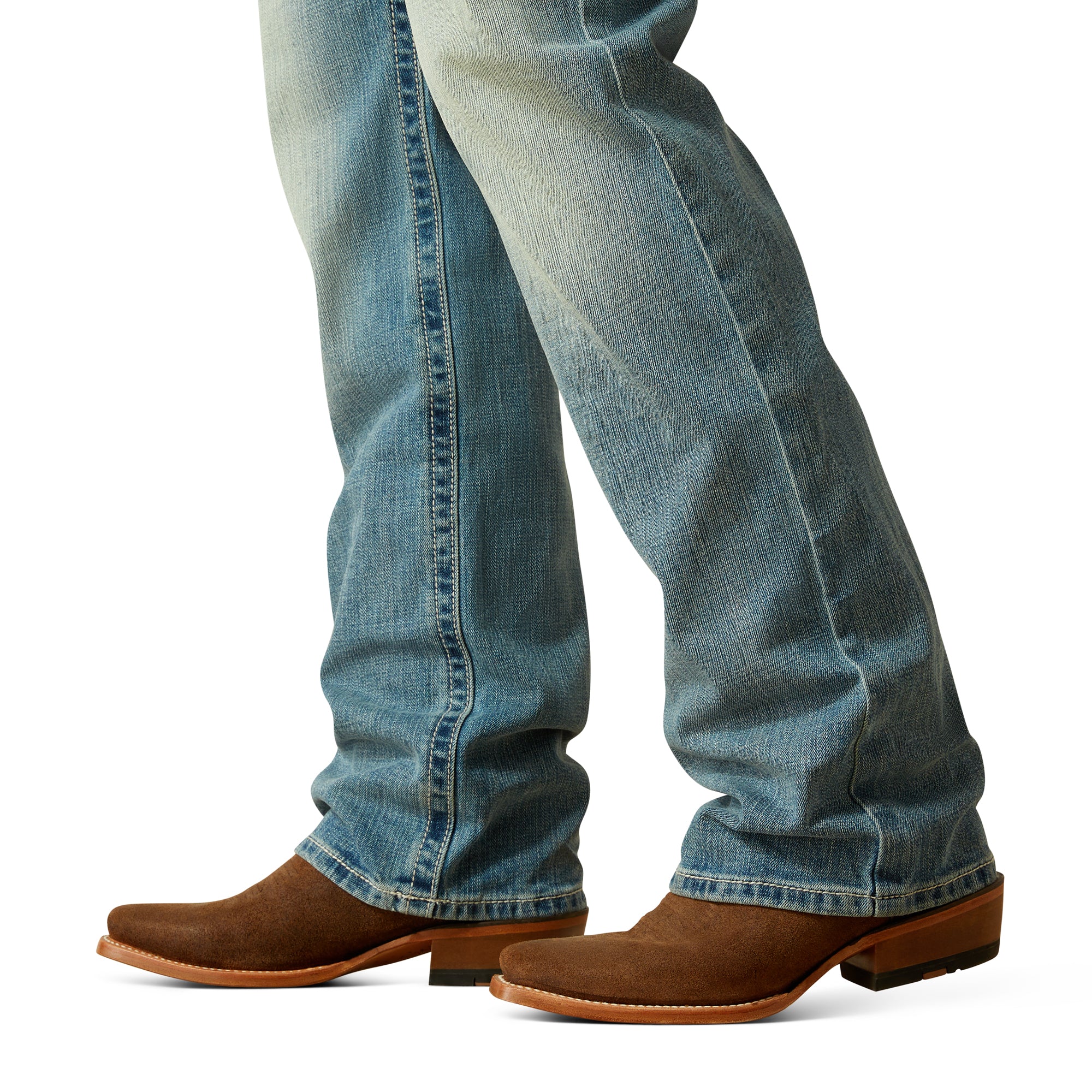 Ariat Men's M4 Thomas Relaxed Boot Cut Jean. Close-up of blue jeans and brown cowboy boots on a white background