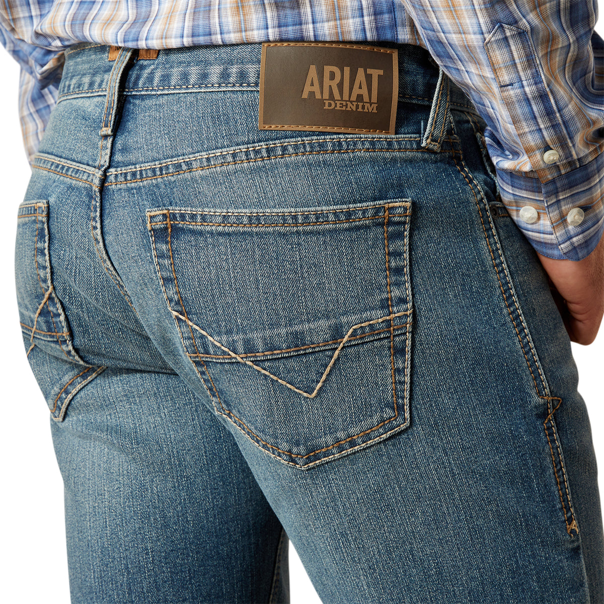 Ariat Men's M7 Jed  Straight Leg Jean. Close-up of blue jeans with Ariat denim label on a white background