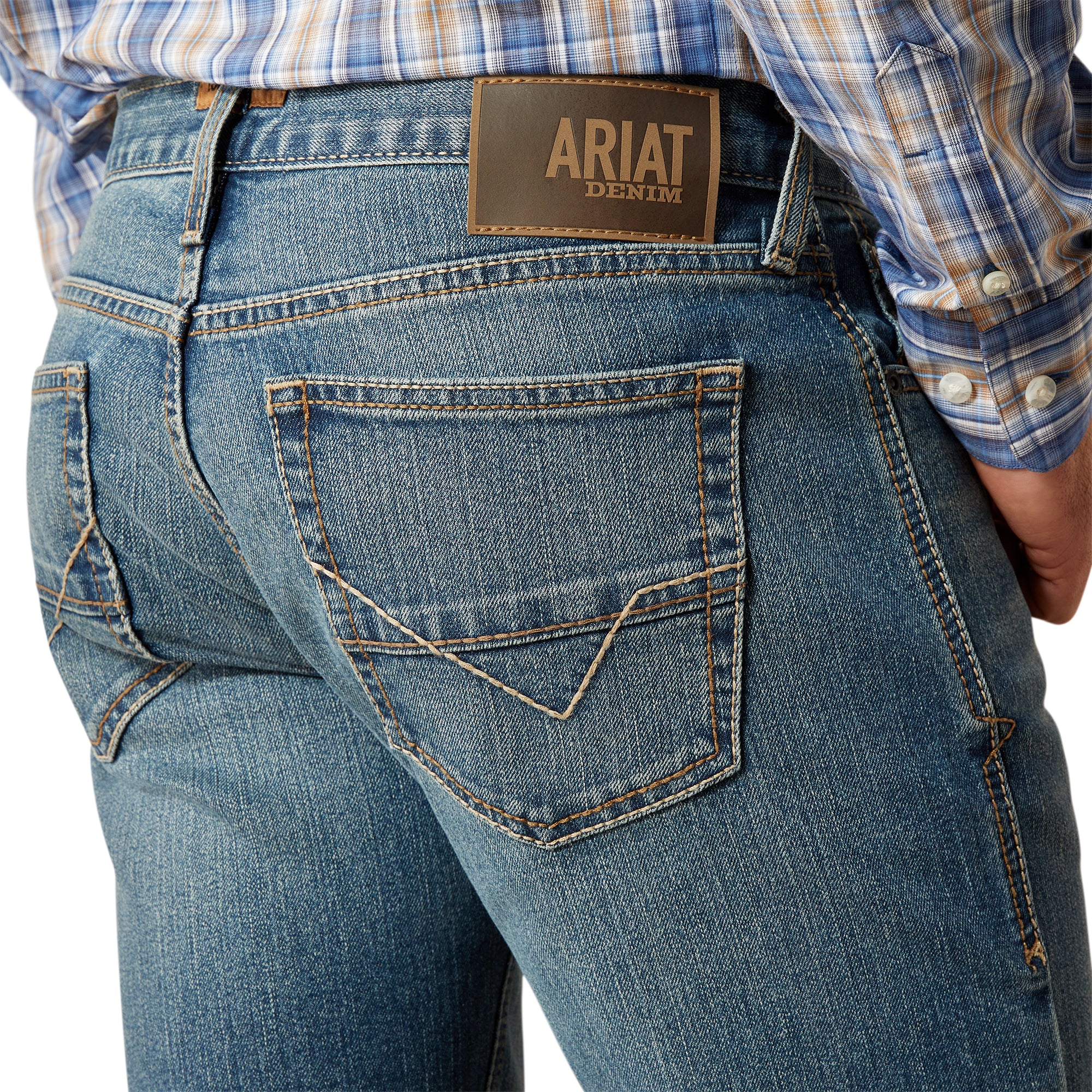Ariat Men's M7 Jed  Straight Leg Jean. Close-up of blue jeans with Ariat denim label on a white background