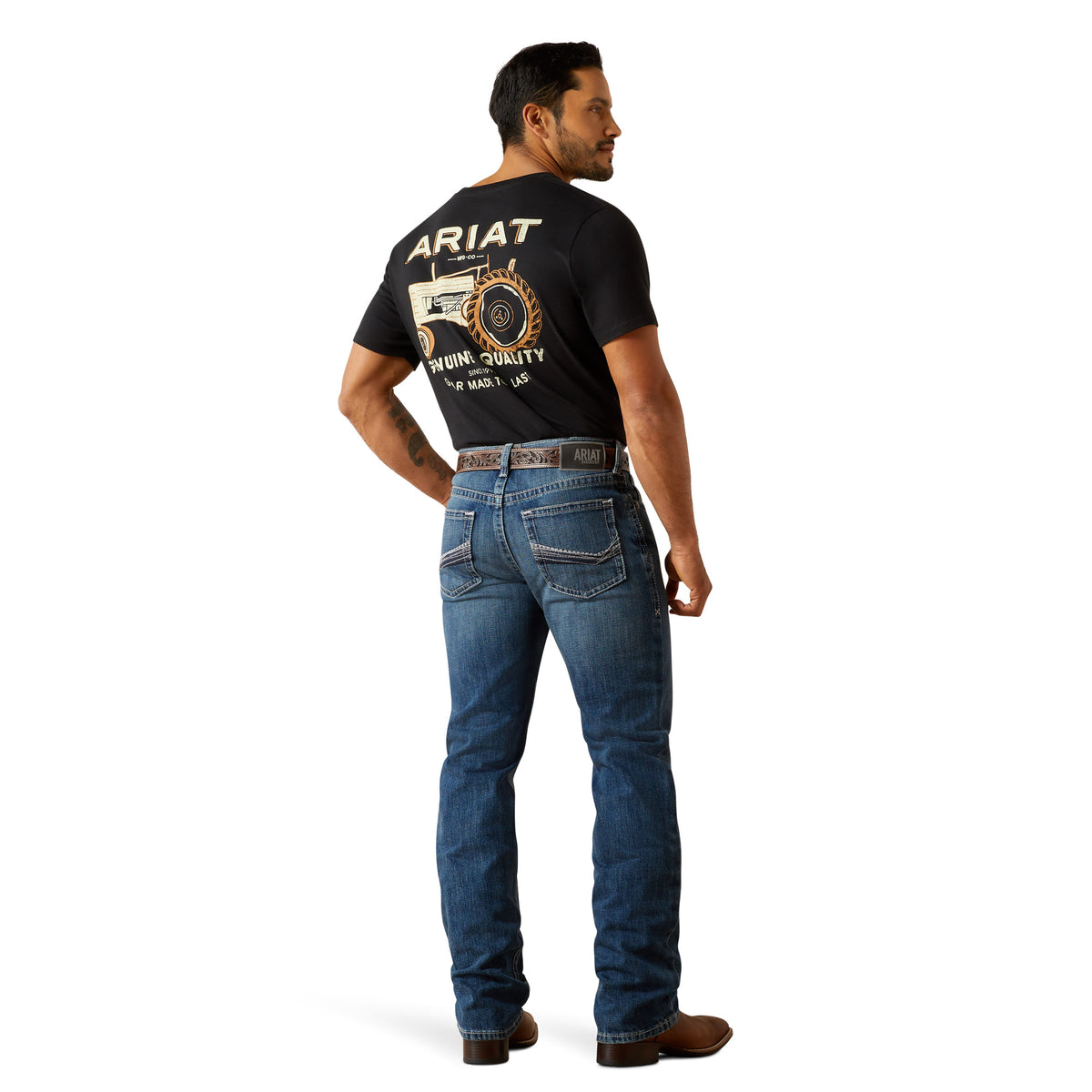 Ariat Men's M4 August Relaxed Straight Leg Jean. Man wearing a black Ariat t-shirt and blue jeans on a white background