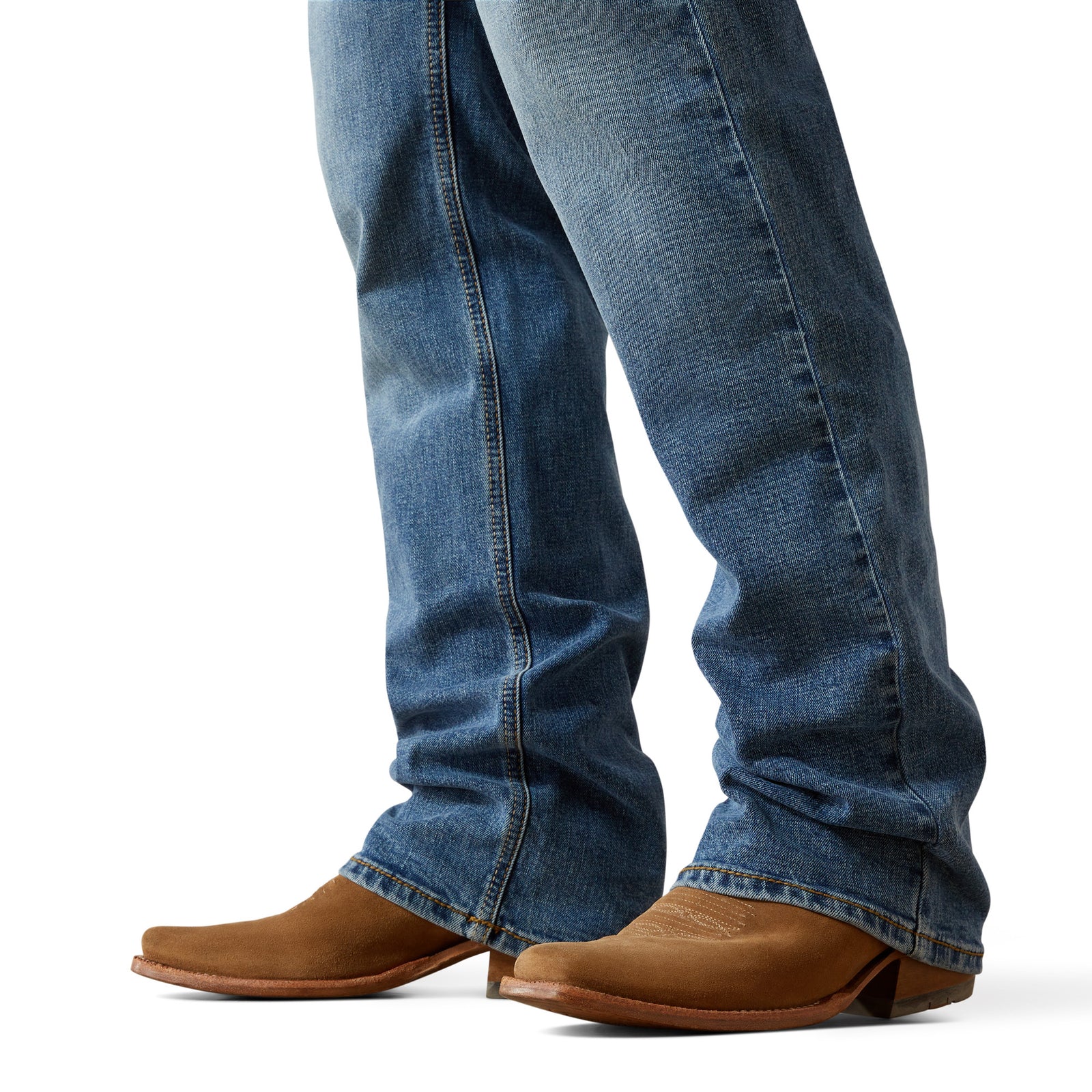 Ariat Men's M4 Pickett Relaxed Boot Cut Jean. Blue jeans worn by a person with brown boots on a white background