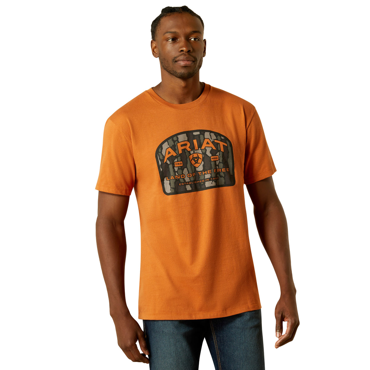 Ariat Men&#39;s Underlands Camo Badge T-Shirt. Man wearing an orange t-shirt with a logo on a white background