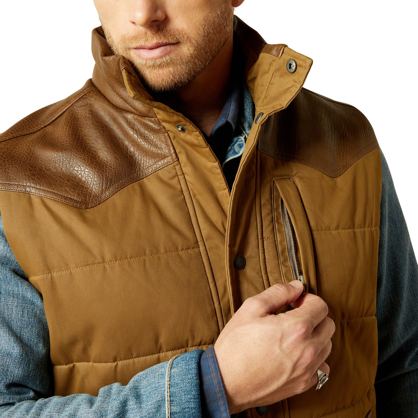 Brown leather and quilted vest worn by a person on a white background
