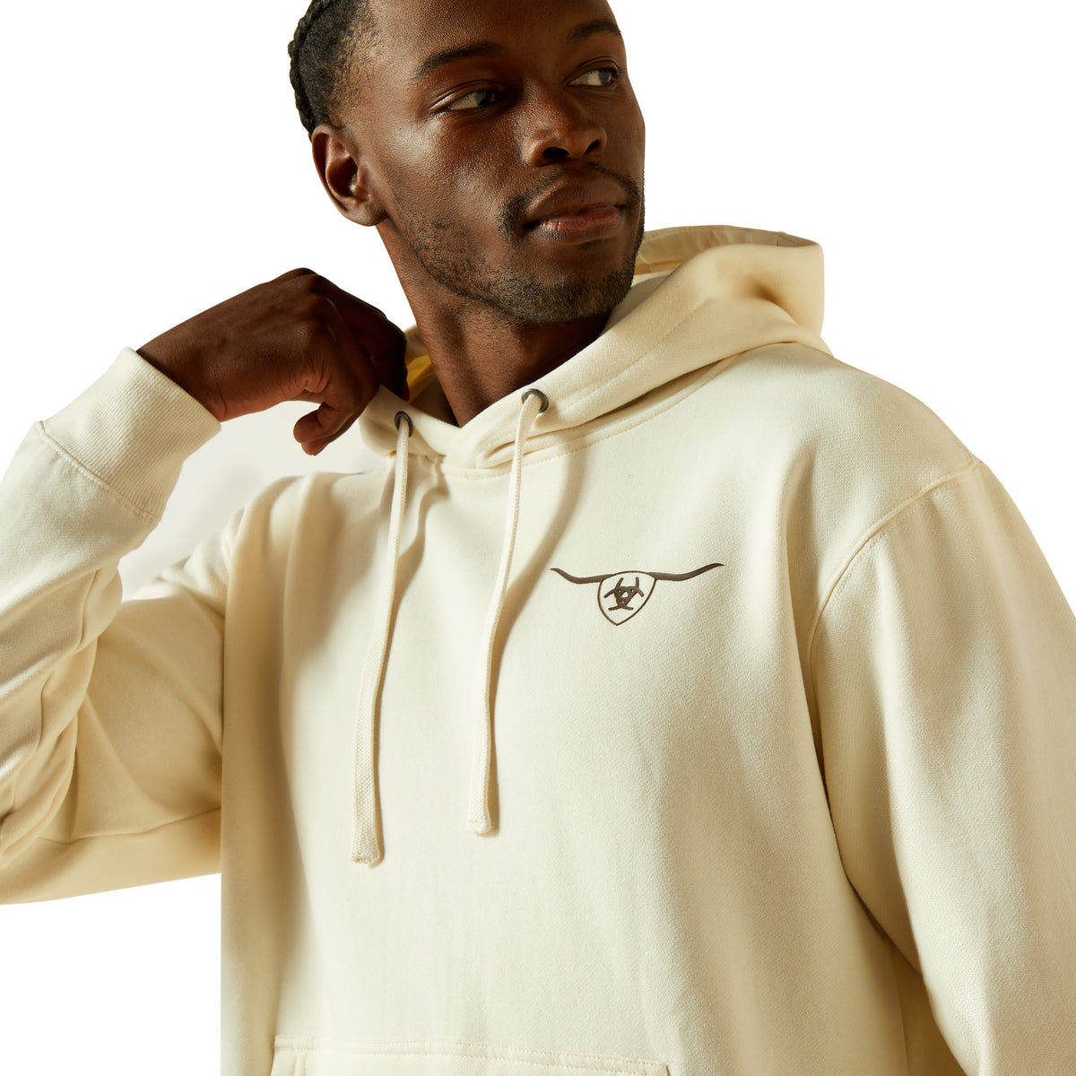 Man wearing a beige hoodie with a logo on a white background