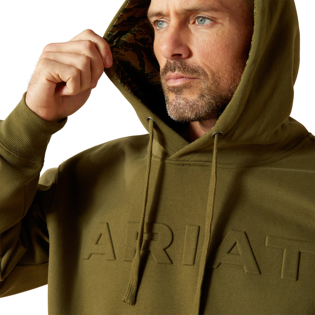 Man wearing a green hoodie with 'Ariat' branding on a white background
