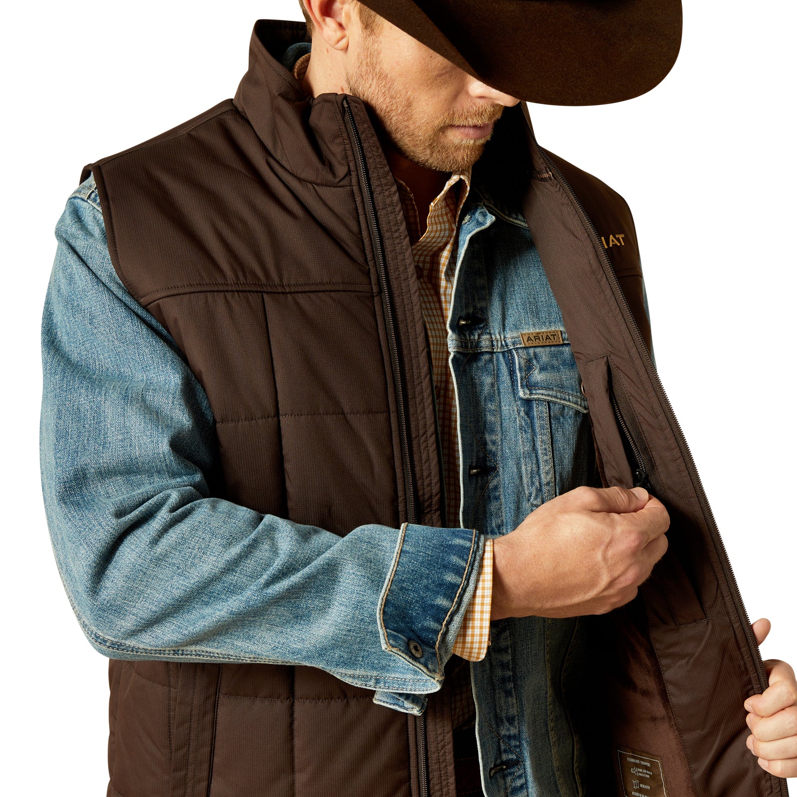 Man wearing a brown vest over a denim jacket with a white background