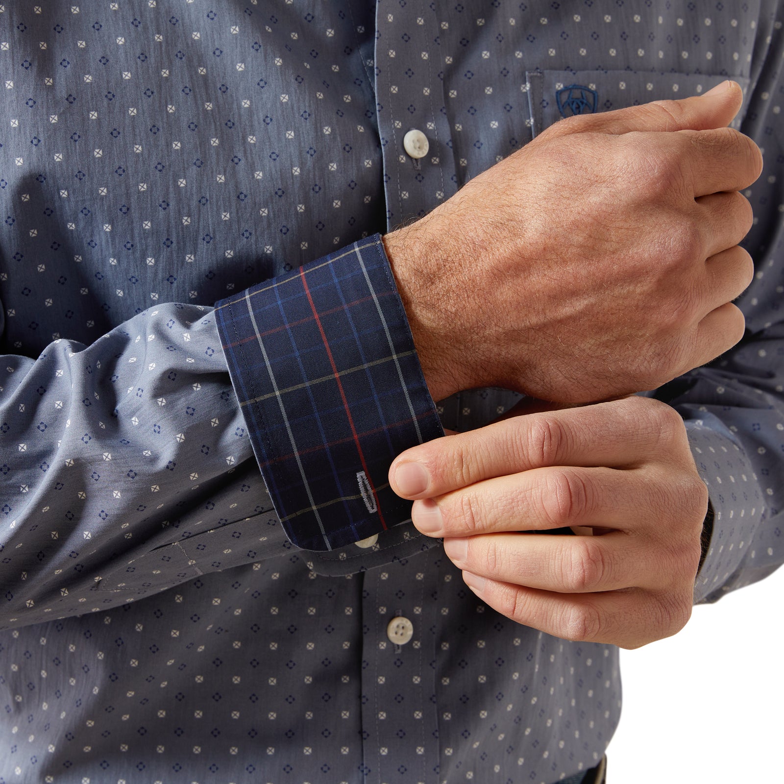 Man wearing a blue patterned shirt and jeans on a white background