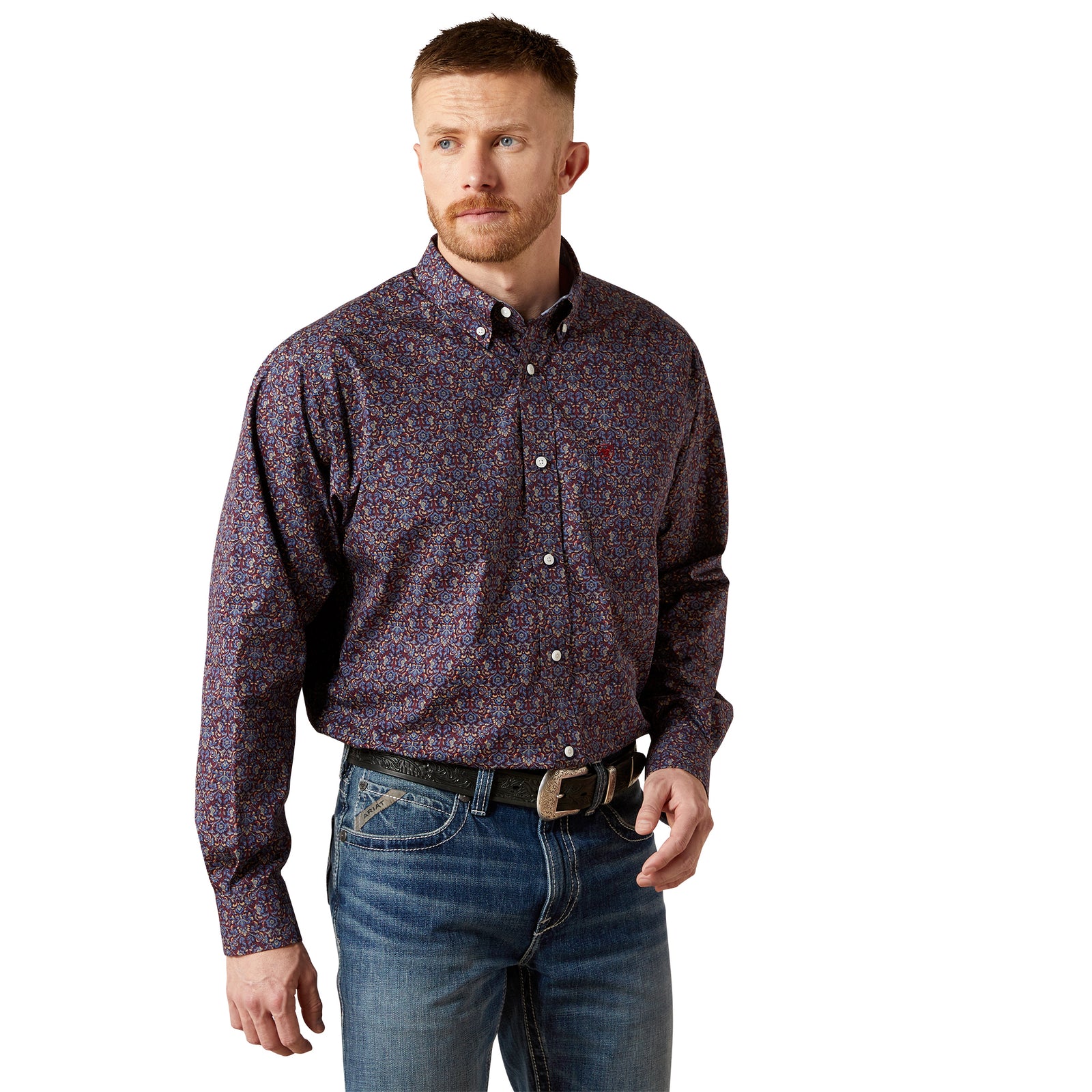 Man wearing a patterned shirt and jeans on a white background