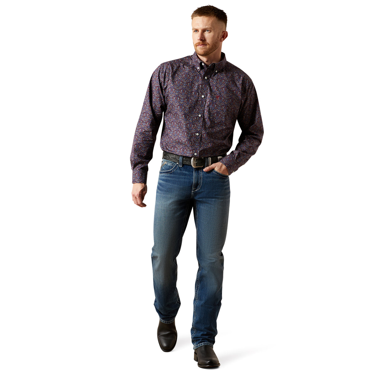 Man wearing a patterned shirt and jeans on a white background
