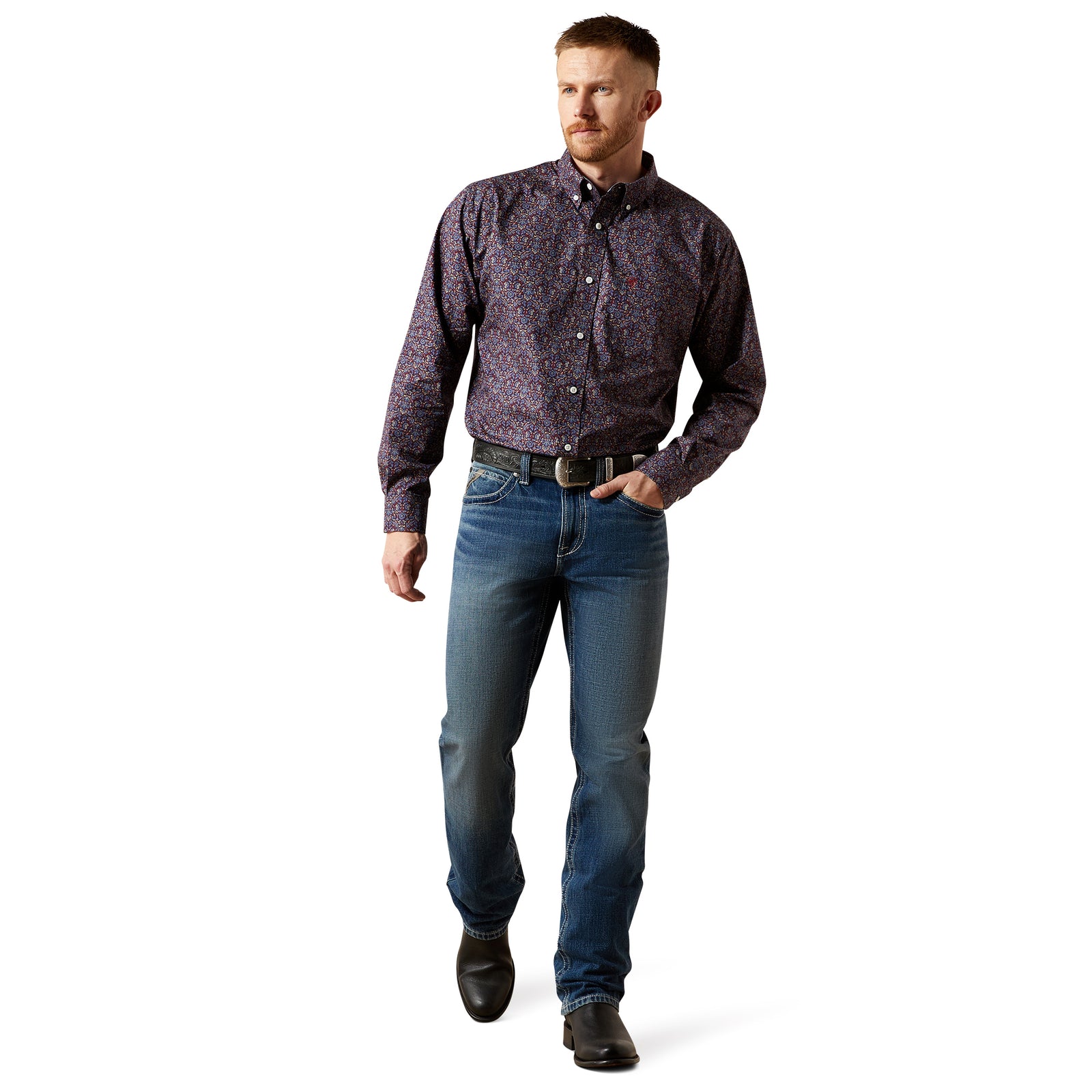 Man wearing a patterned shirt and jeans on a white background