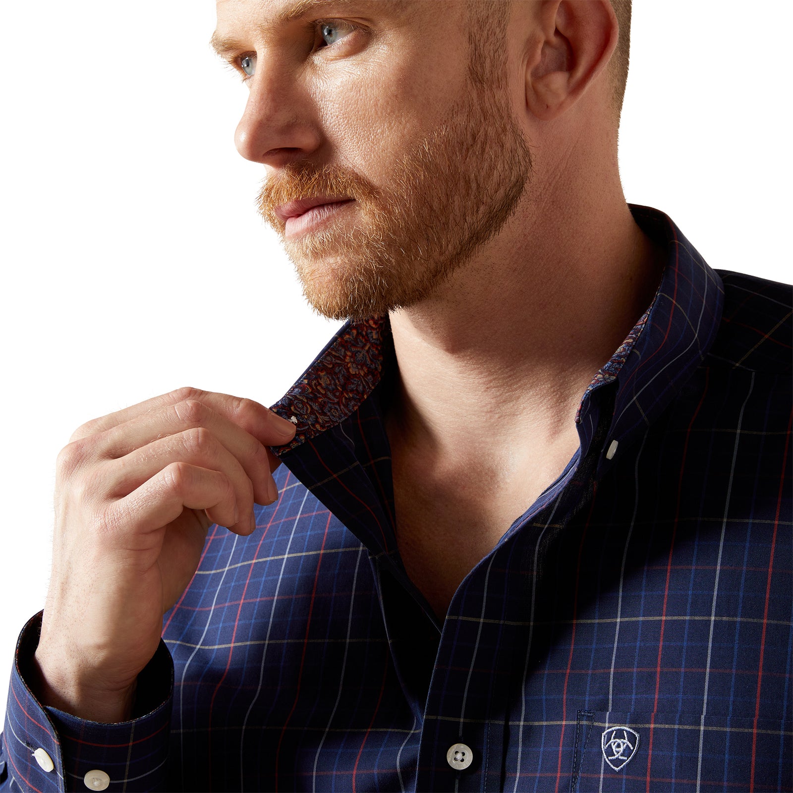 Man wearing a blue checkered shirt with a patterned tie against a white background