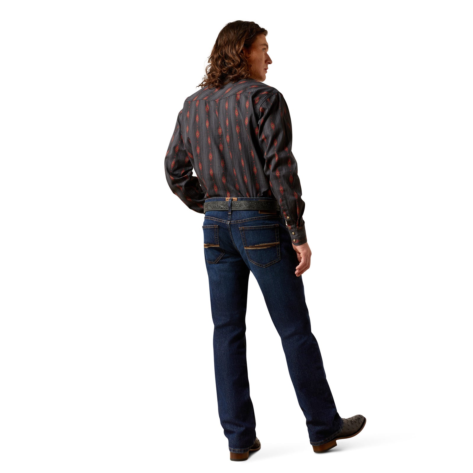Person wearing a patterned shirt, jeans, and brown shoes on a white background