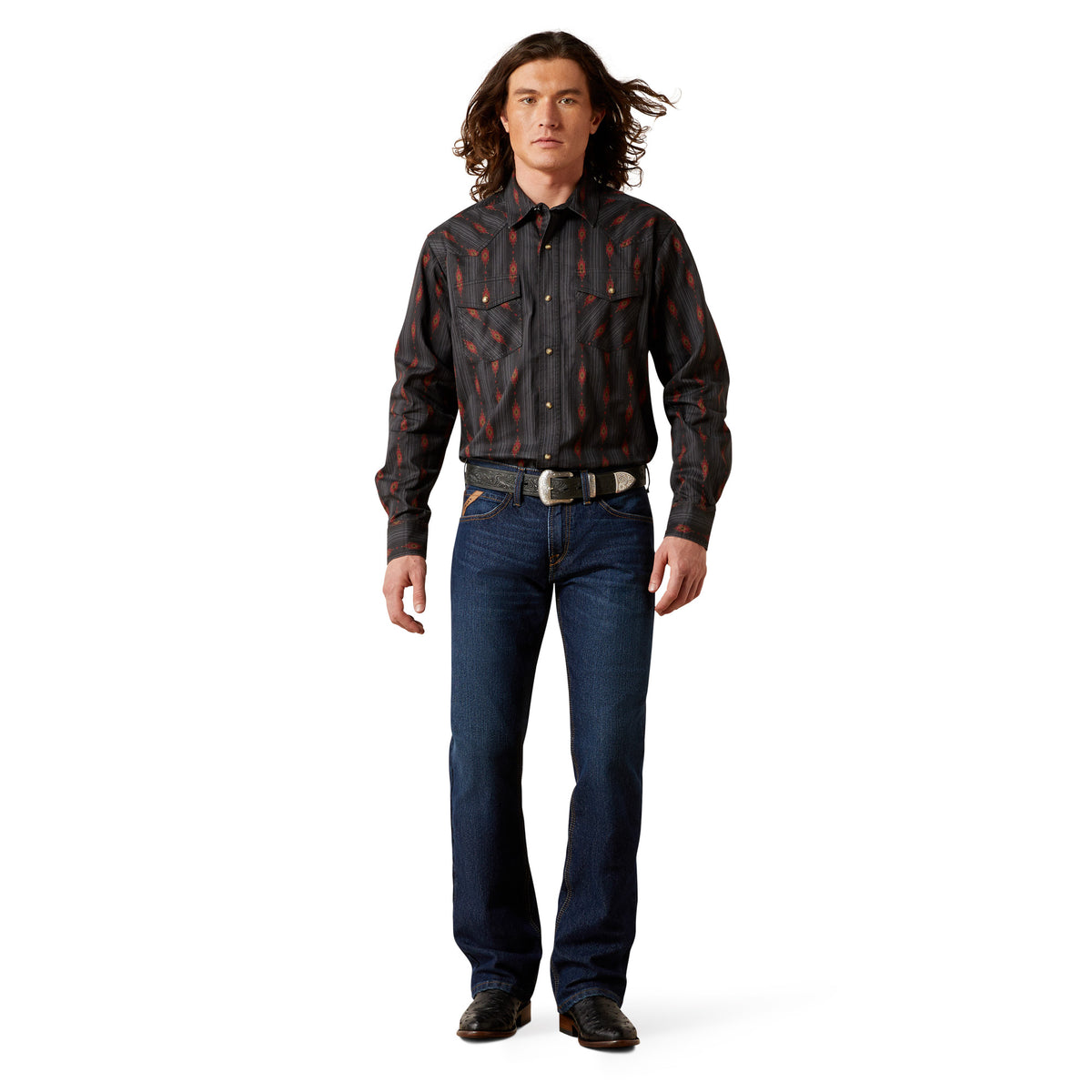 Man wearing a patterned shirt and jeans on a white background