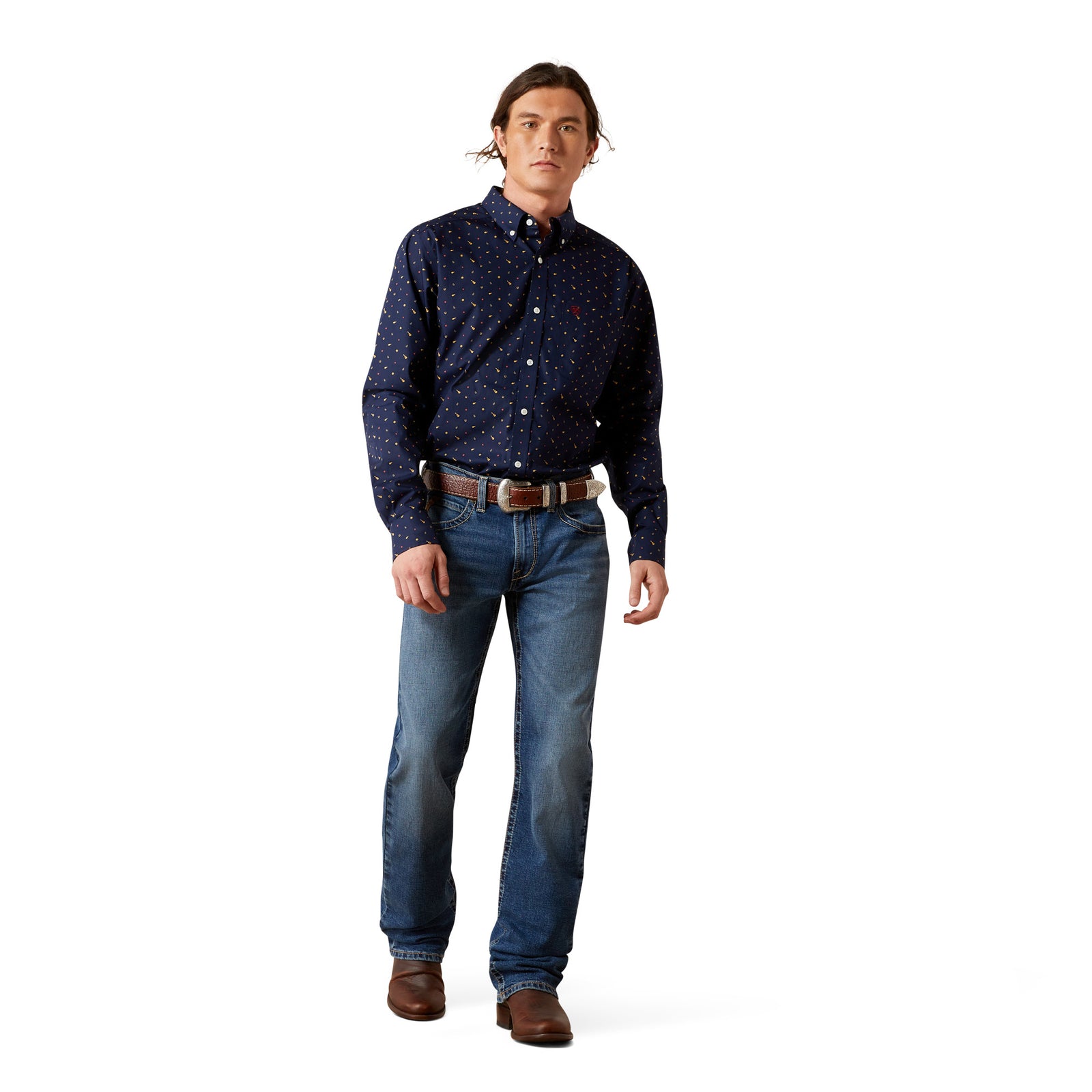 Man wearing a navy patterned shirt and blue jeans on a white background