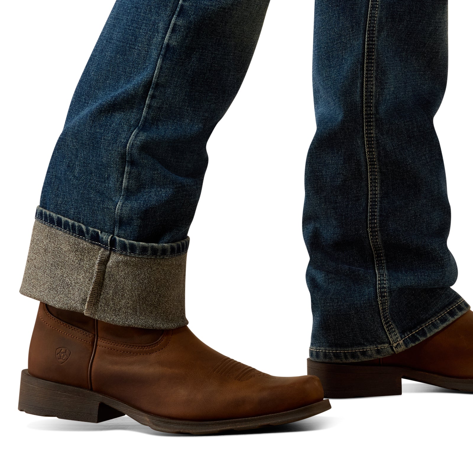 Brown leather boots with rolled-up jeans on a white background