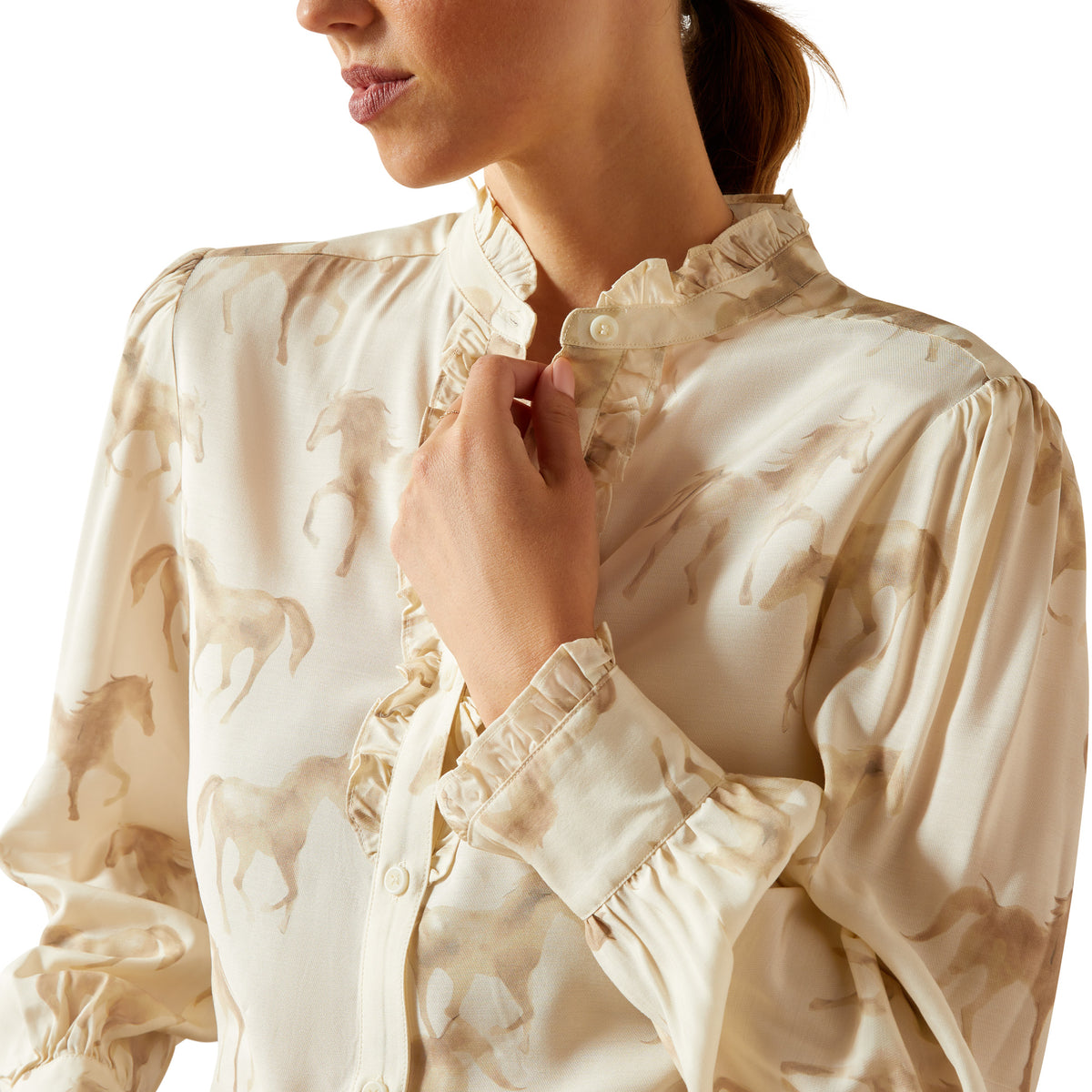 Close-up of a woman wearing a beige blouse with floral patterns on a white background