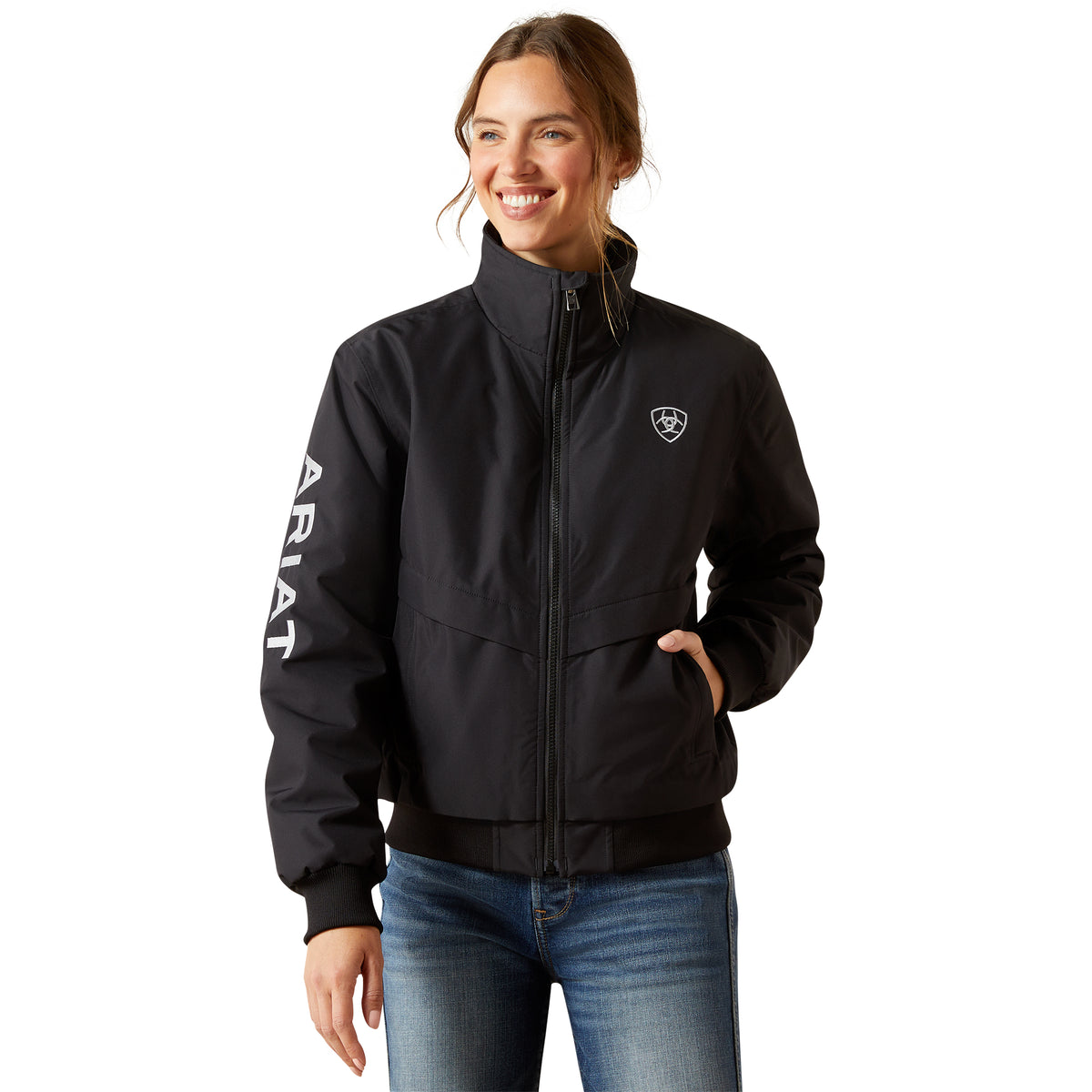 Woman wearing a black jacket with 'Ariat' branding on a white background