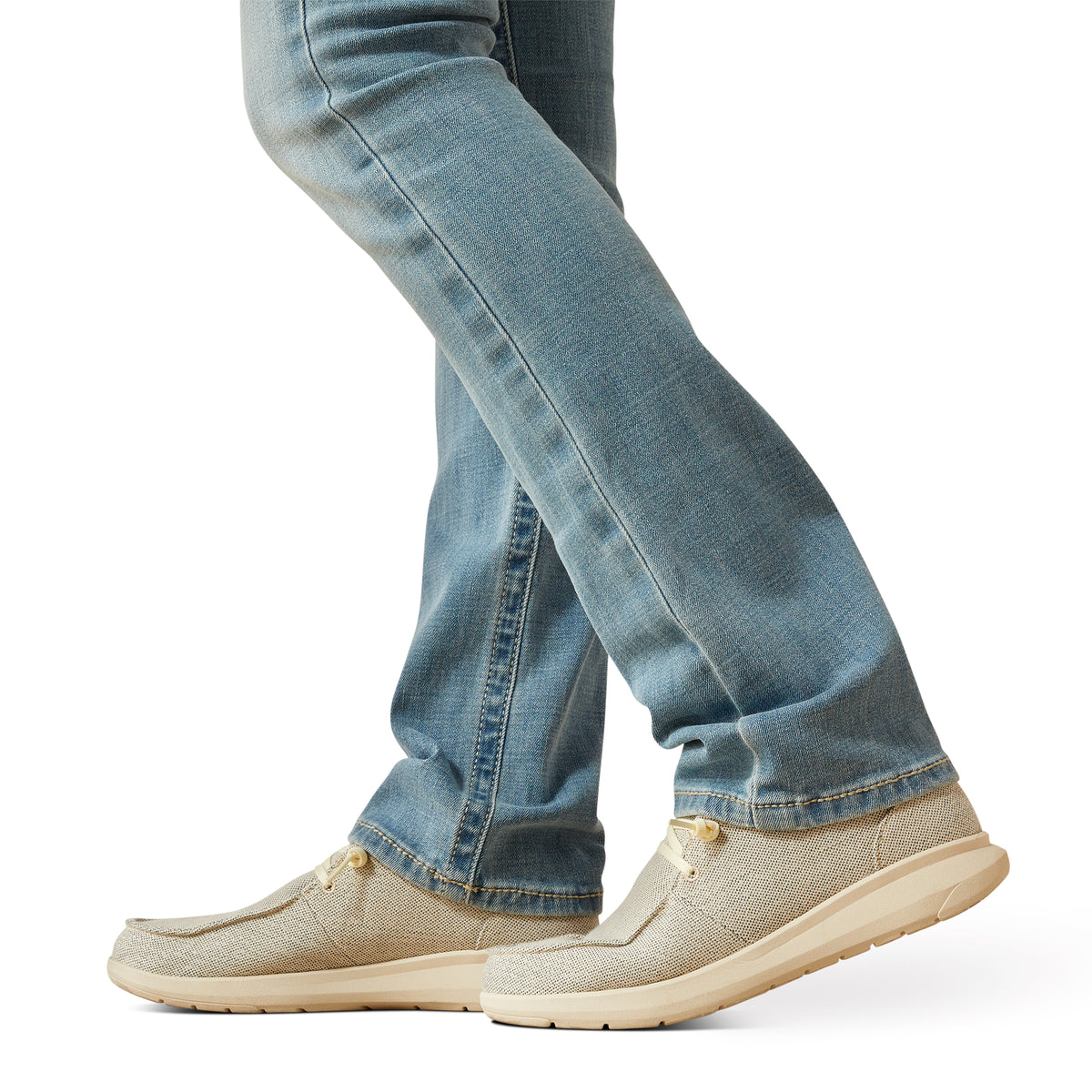 Ariat Women's Alina Perfect Rise Straight Leg Jean. Beige slip-on shoes worn with blue jeans on a white background