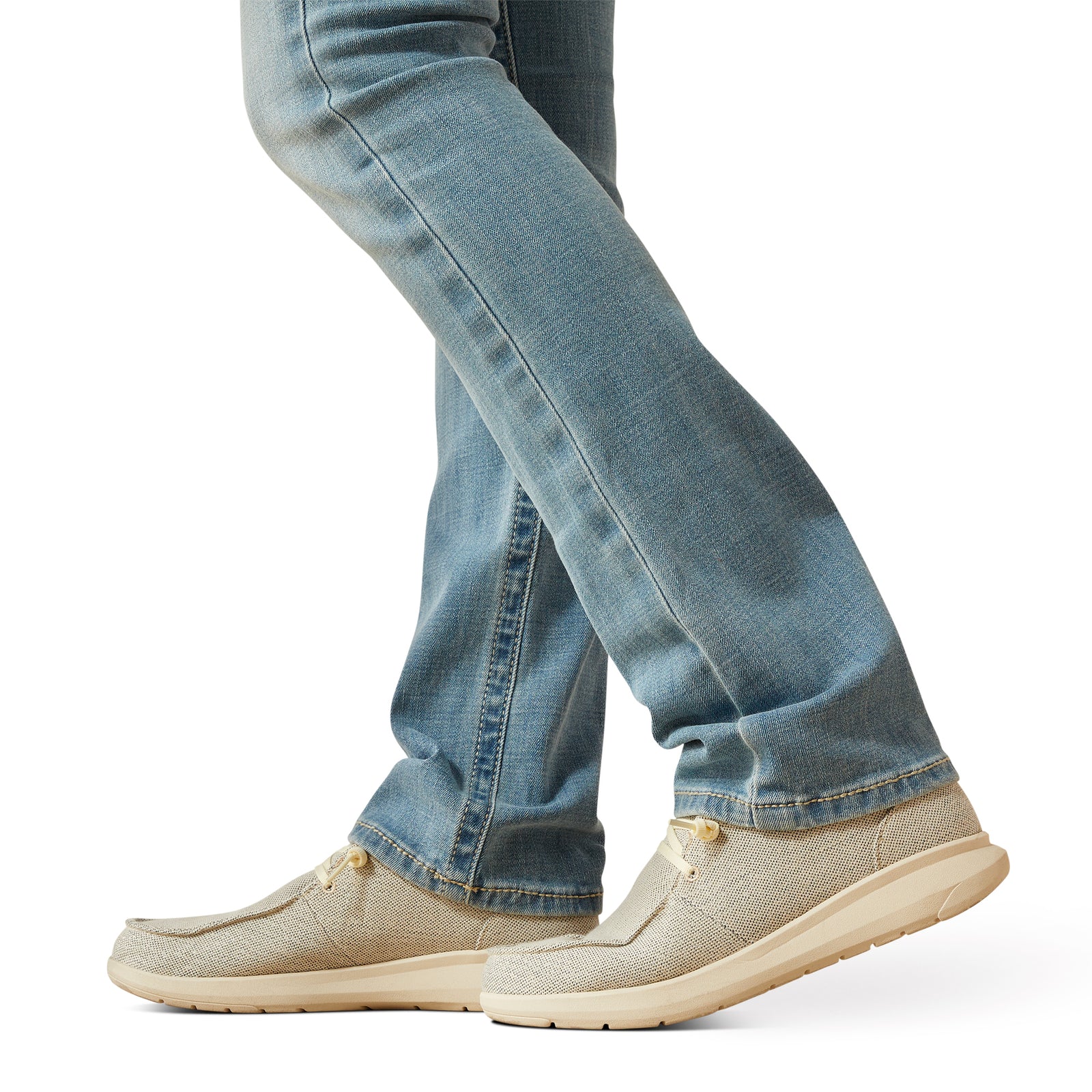 Ariat Women's Alina Perfect Rise Straight Leg Jean. Beige slip-on shoes worn with blue jeans on a white background