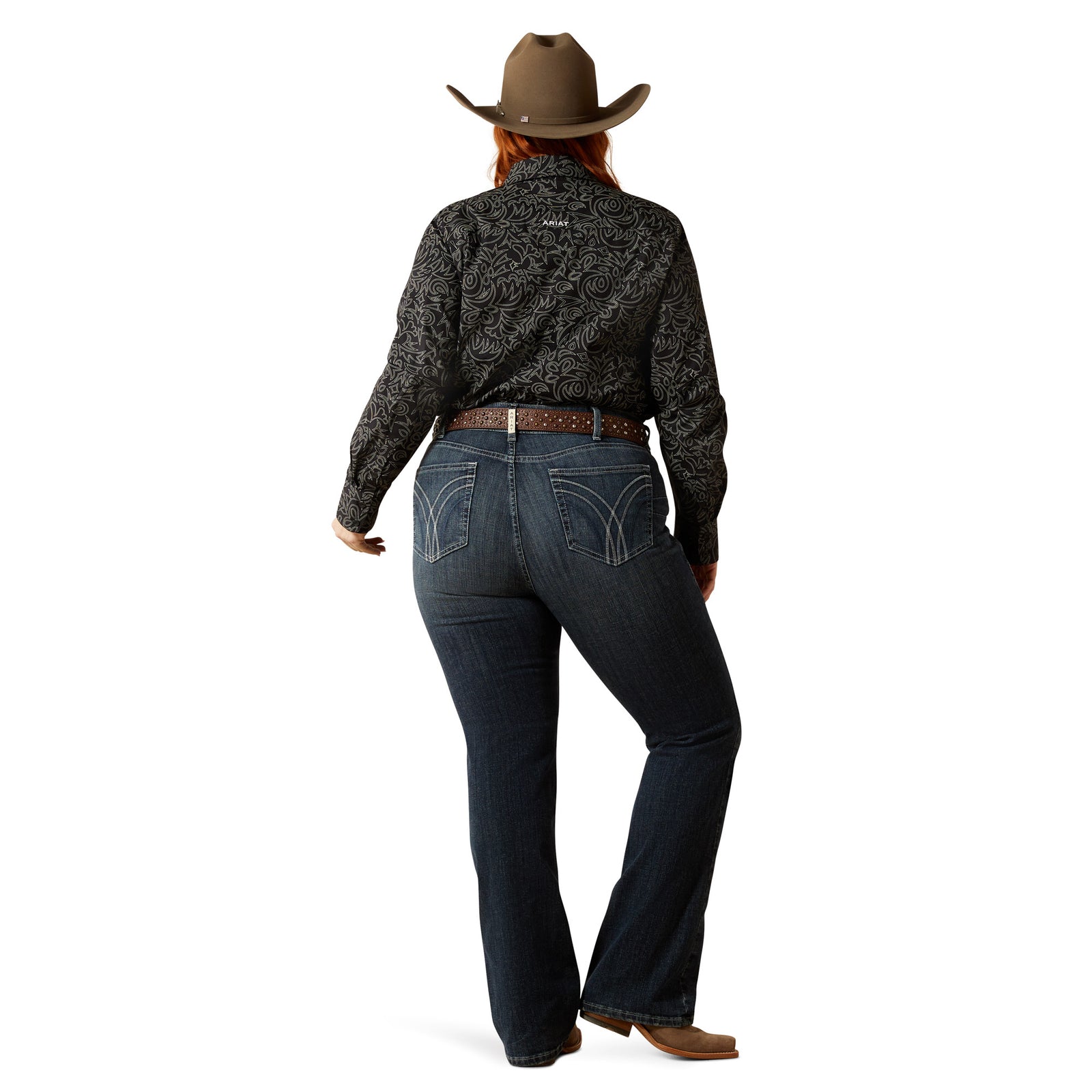 Ariat Women's Esti Perfect Rise Boot Cut Jean. Person wearing a patterned long-sleeve shirt, jeans, and a cowboy hat on a white background