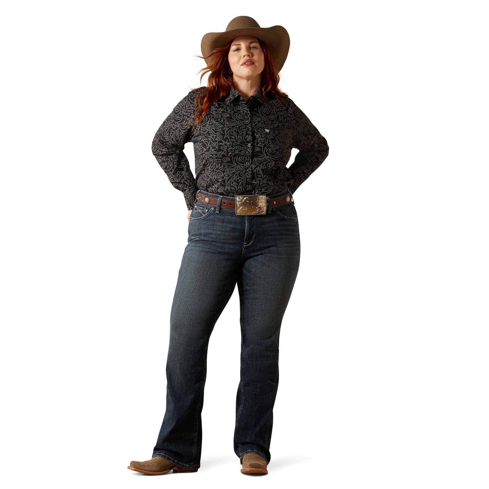 Ariat Women's Esti Perfect Rise Boot Cut Jean. Woman wearing a patterned shirt, jeans, and a cowboy hat on a white background