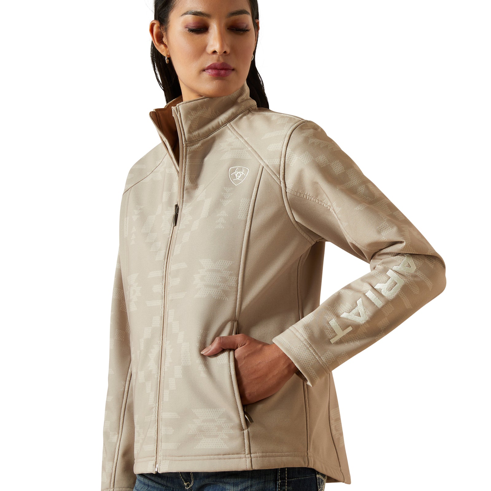 Woman wearing a beige jacket with a brand logo on a white background