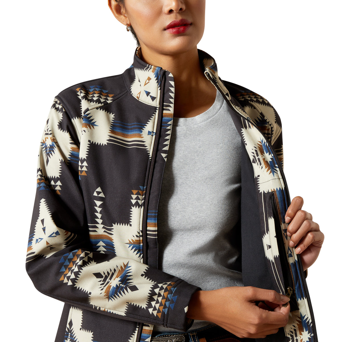 Woman wearing a patterned jacket over a gray shirt on a white background