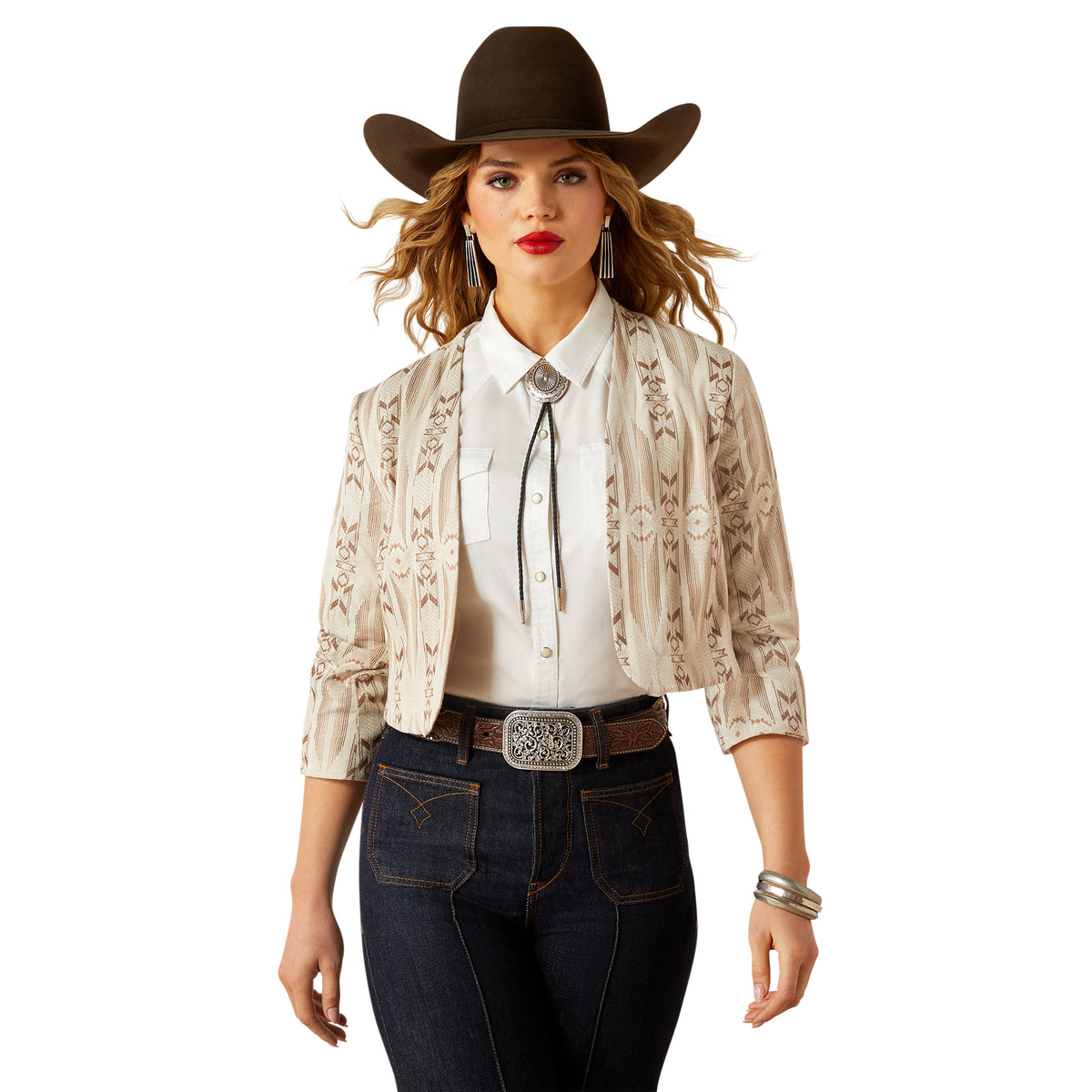 Woman wearing a cowboy hat, white blouse, patterned jacket, and dark jeans on a white background