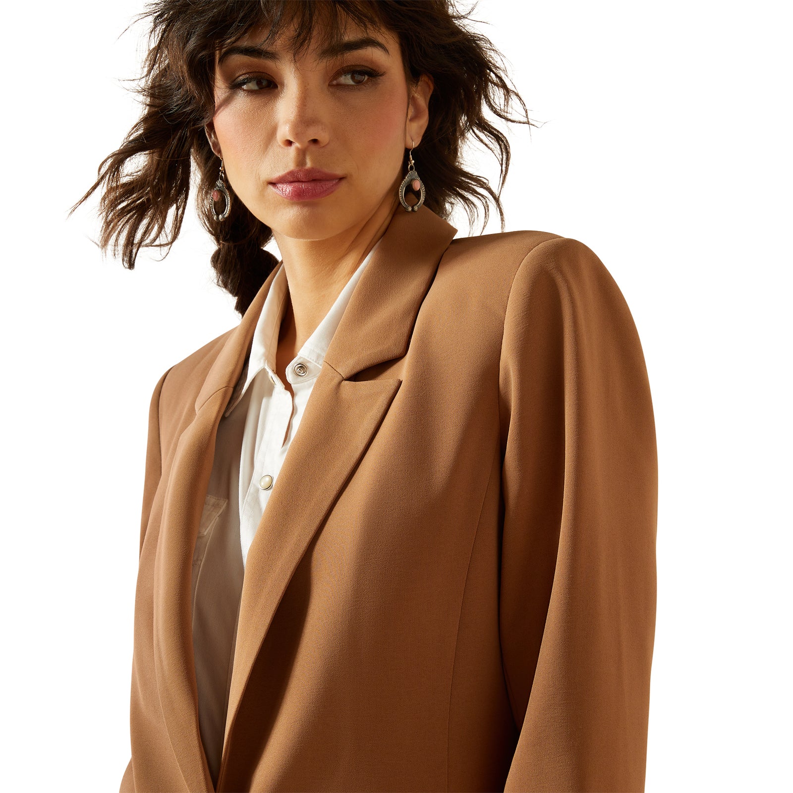 Woman wearing a brown blazer over a white shirt on a white background