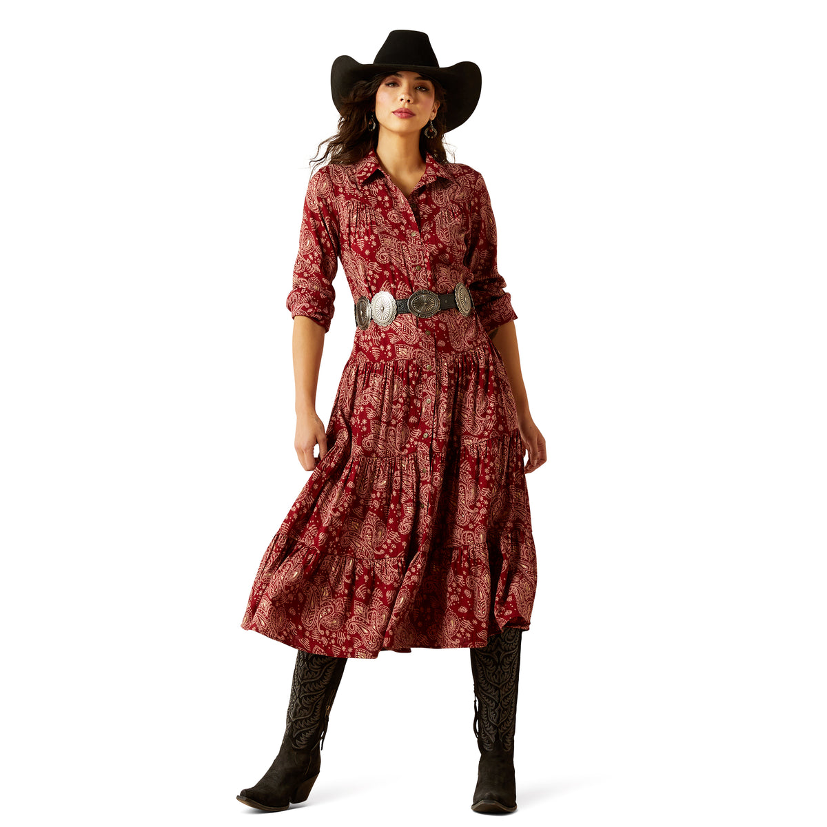 Woman wearing a red patterned dress with a black cowboy hat and boots on a white background