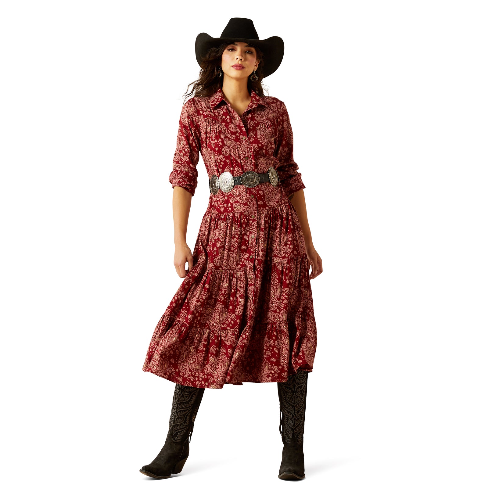 Woman wearing a red patterned dress with a black cowboy hat and boots on a white background