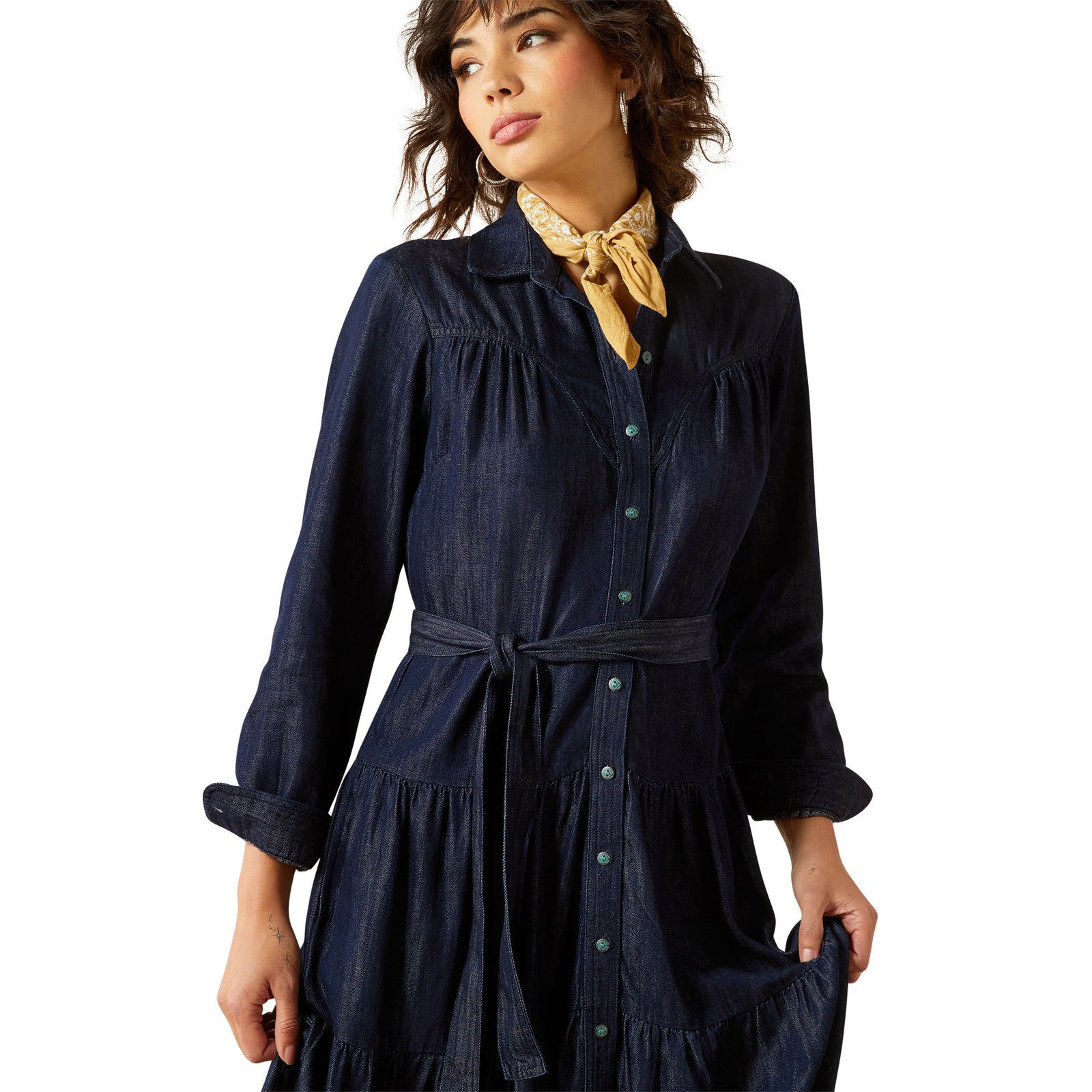Woman wearing a navy dress with a yellow scarf on a white background