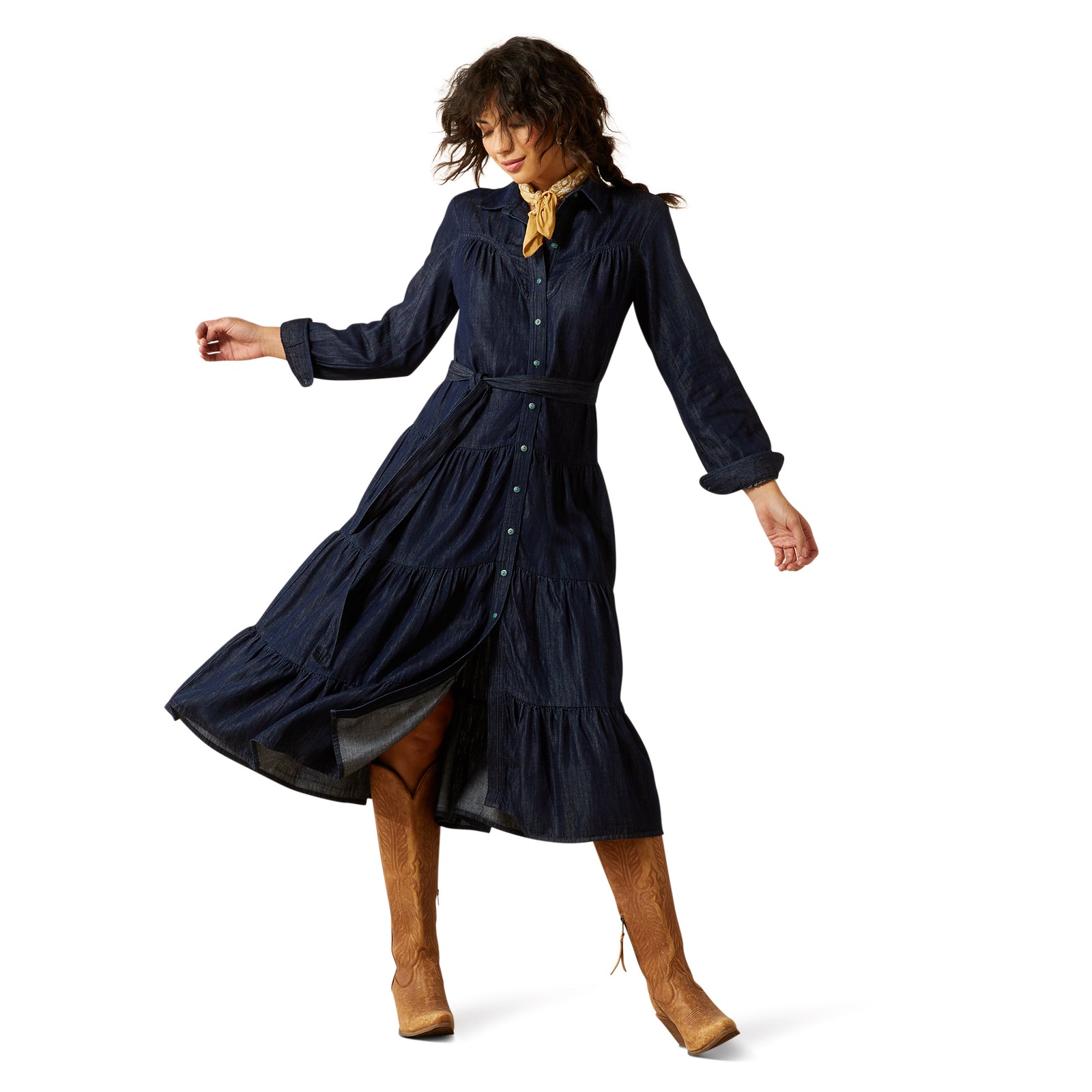 Woman wearing a navy blue dress with long sleeves and a belt, standing on a white background.