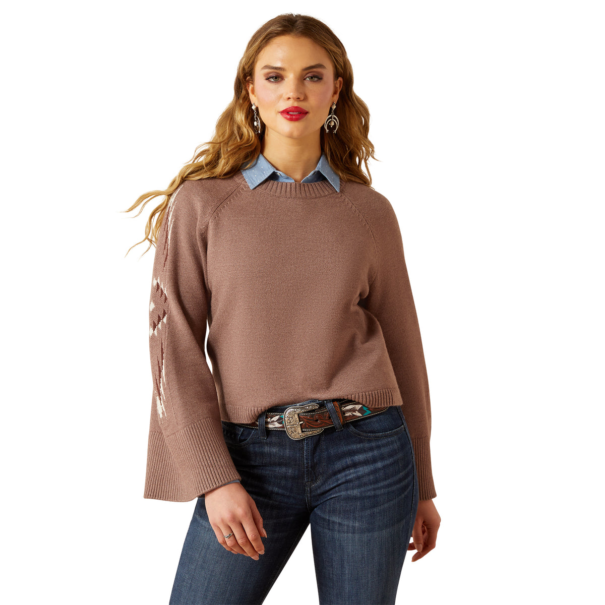 Woman wearing a brown sweater and blue jeans on a white background
