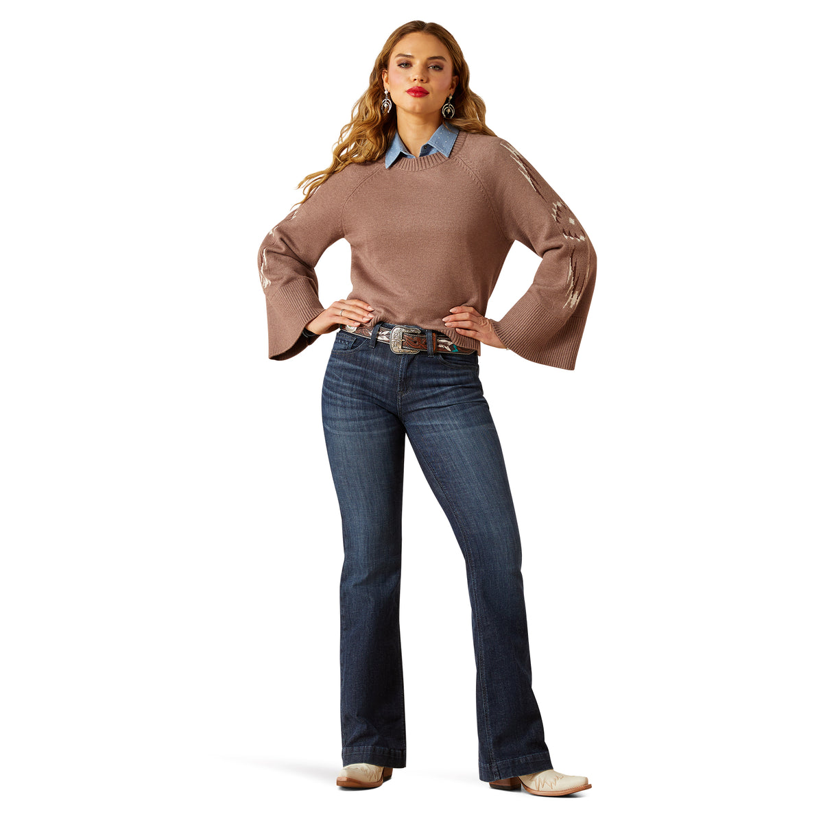 Woman wearing a brown sweater and blue jeans on a white background