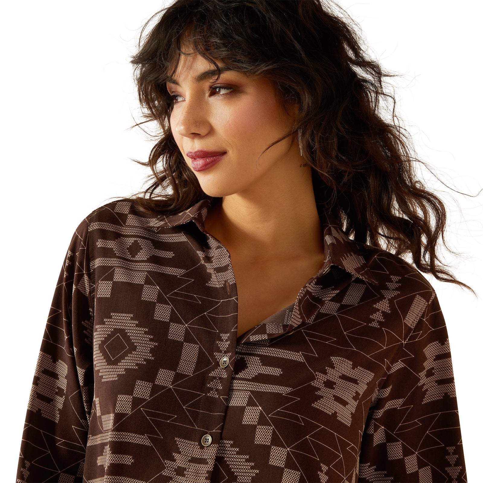 Woman wearing a patterned brown shirt and brown pants on a white background