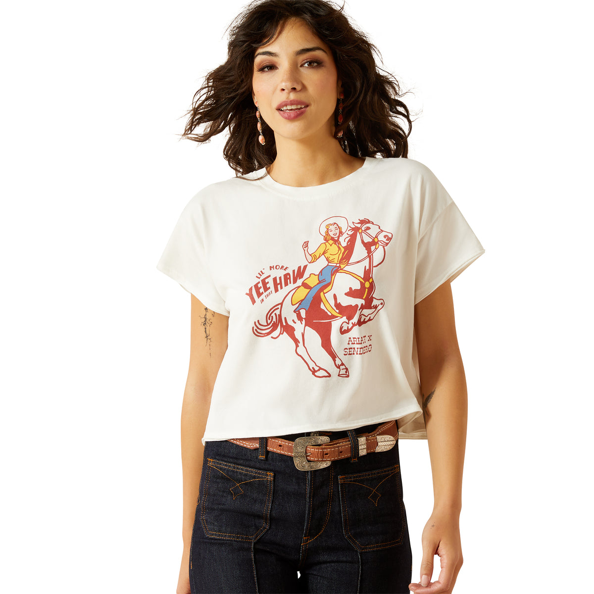 Ariat Women&#39;s Sendero Yeehaw S/S T-Shirt. Woman wearing a white t-shirt with a graphic design on a white background