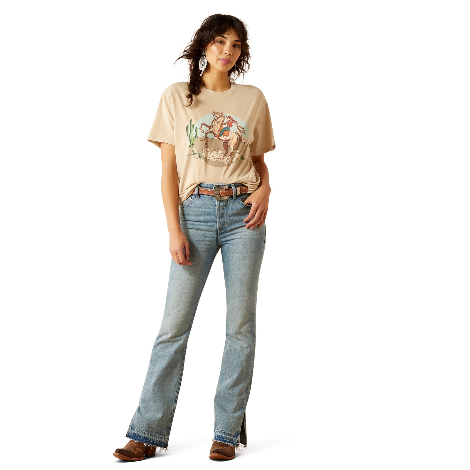Woman wearing a beige graphic t-shirt and light blue jeans on a white background