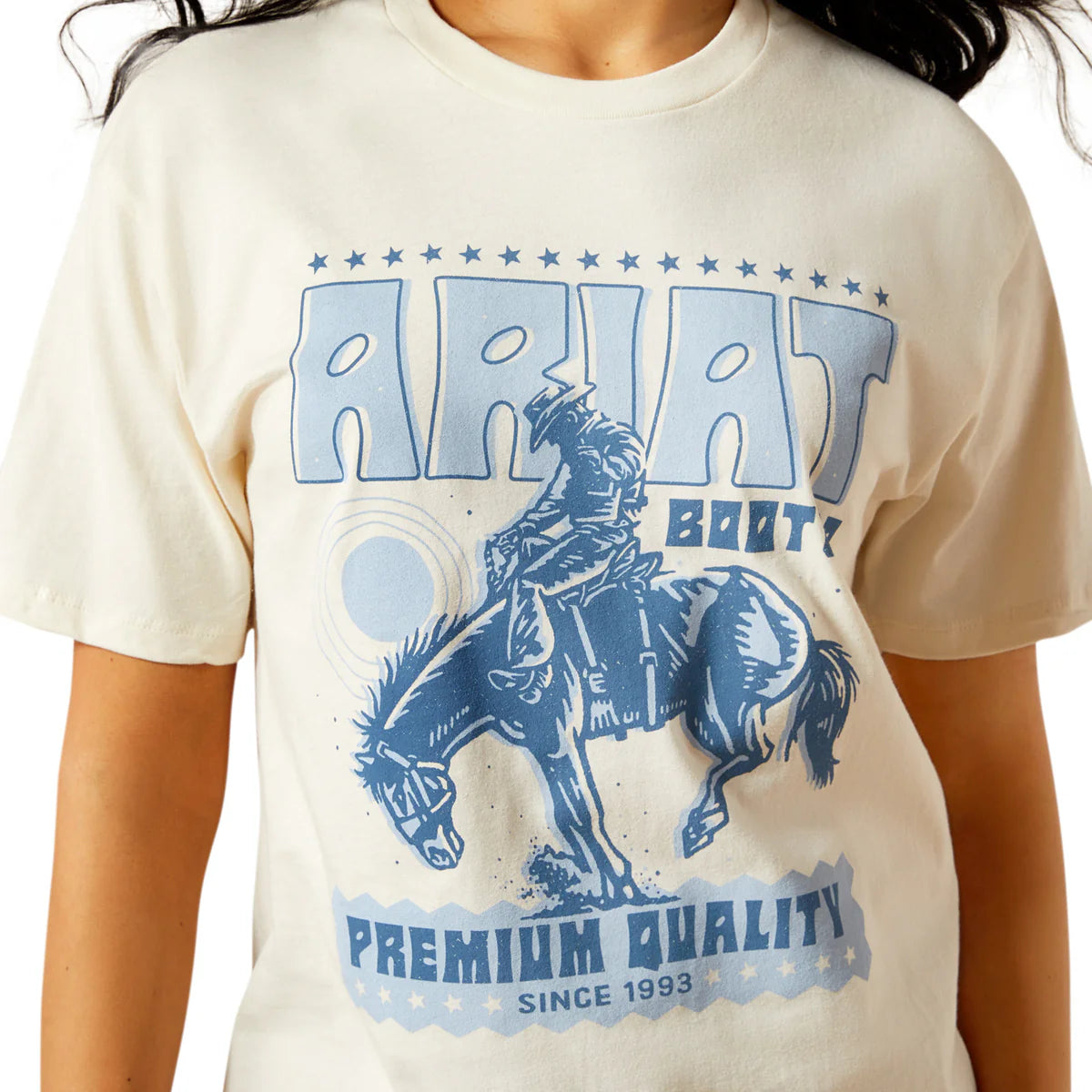 Beige t-shirt with blue graphic of a person riding a horse and 'Ariat Boots' text.