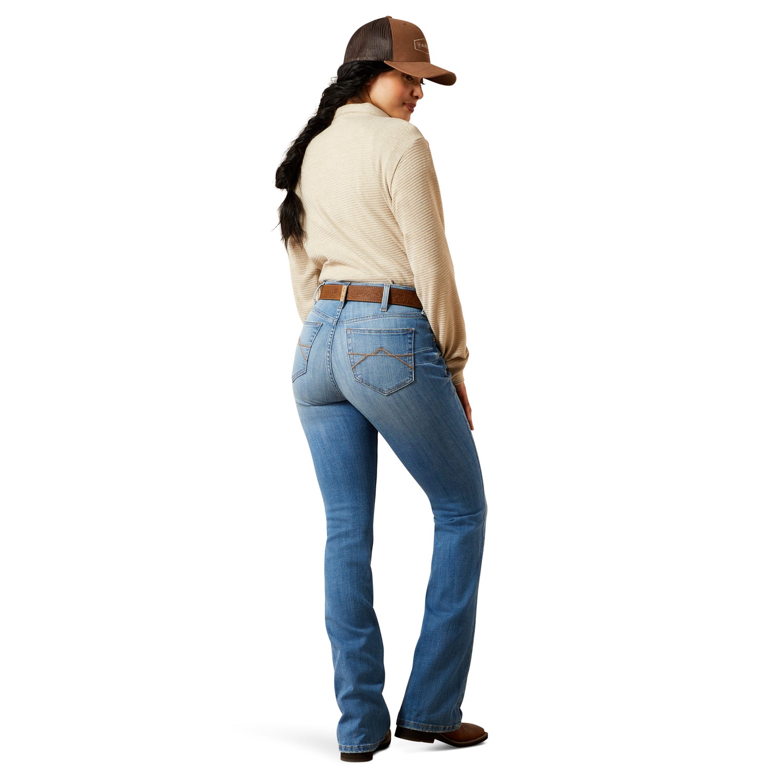 Person wearing blue jeans and a beige jacket on a white background