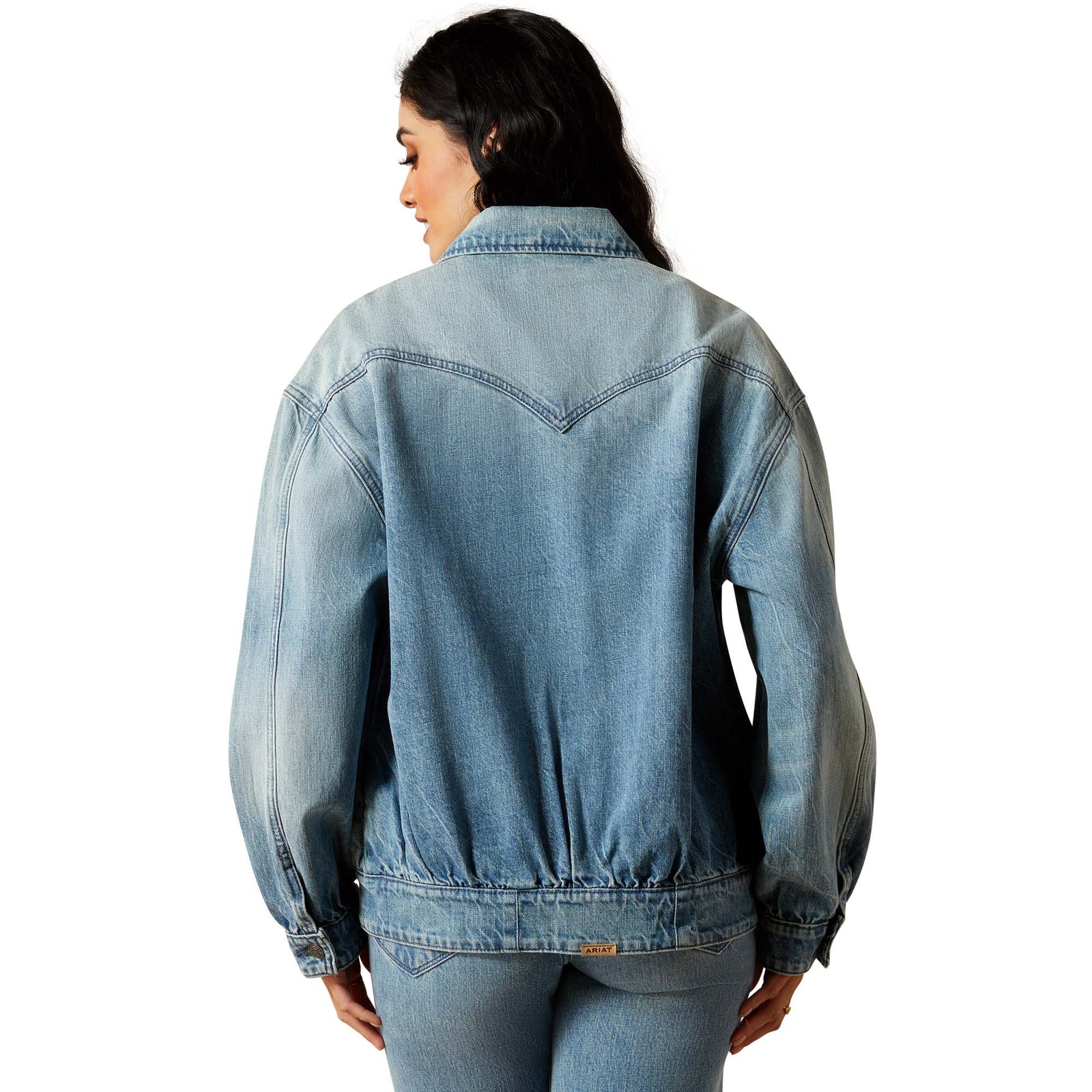 Woman wearing a light blue denim jacket on a white background