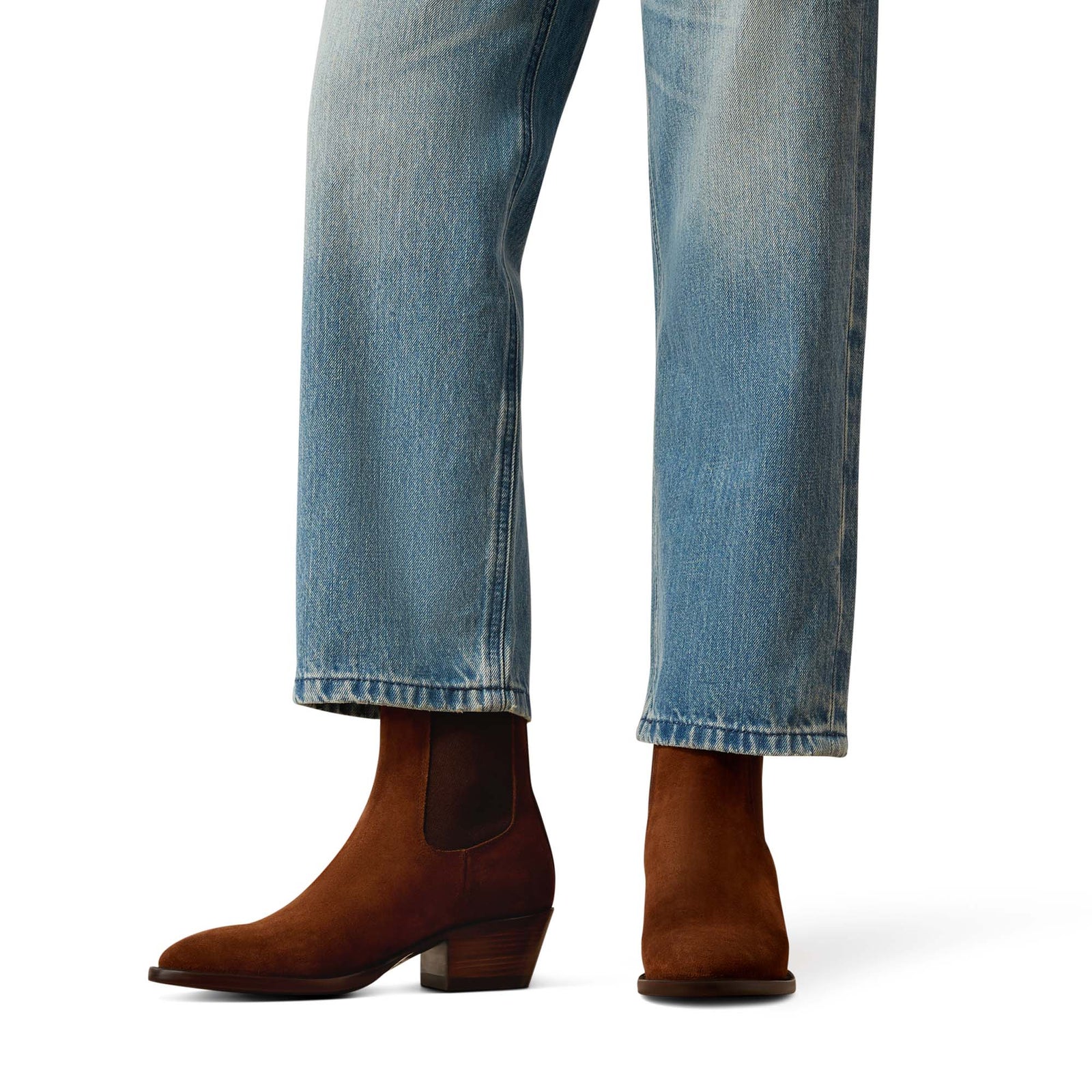 Brown ankle boots worn with blue jeans on a white background