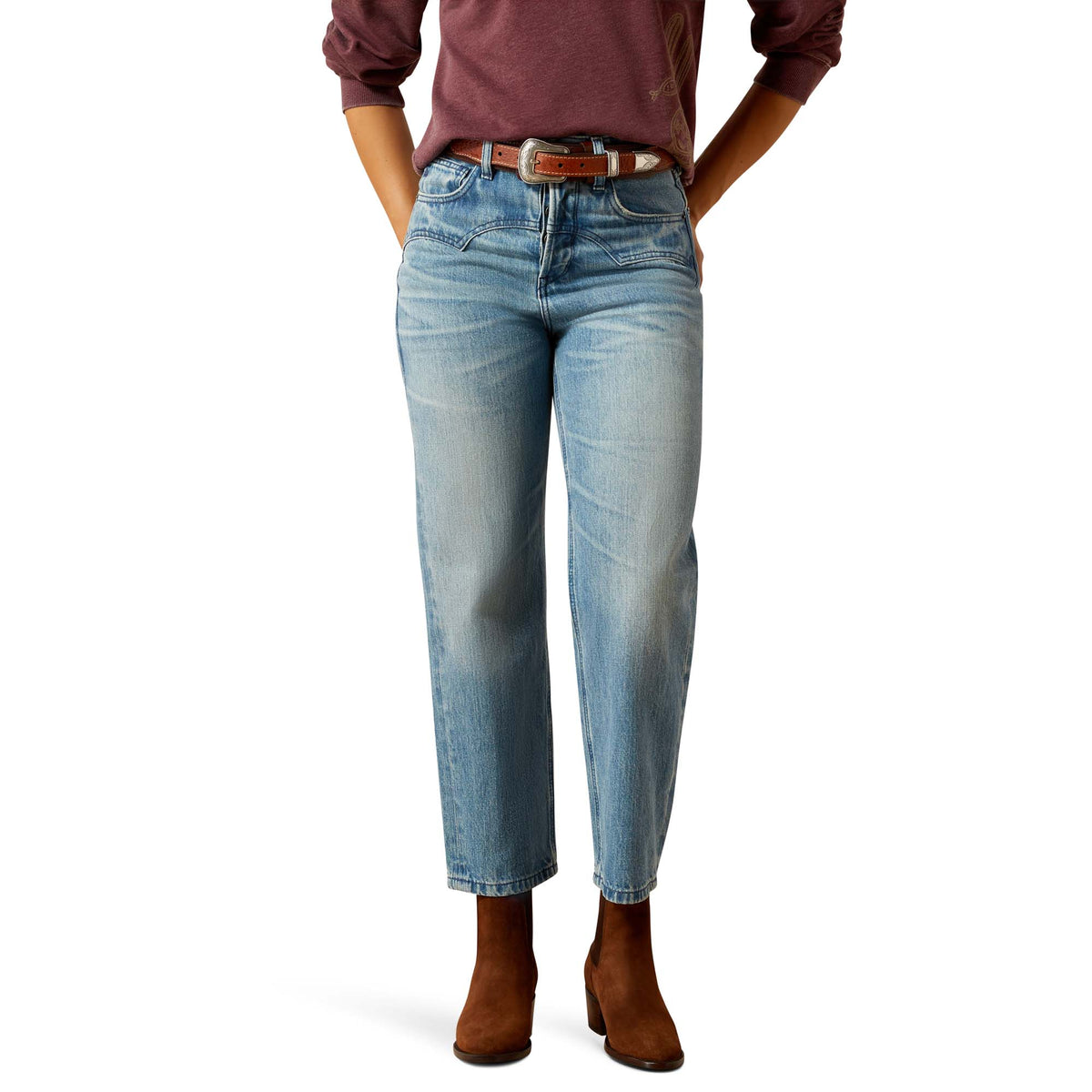 Person wearing light blue jeans and brown shoes on a white background