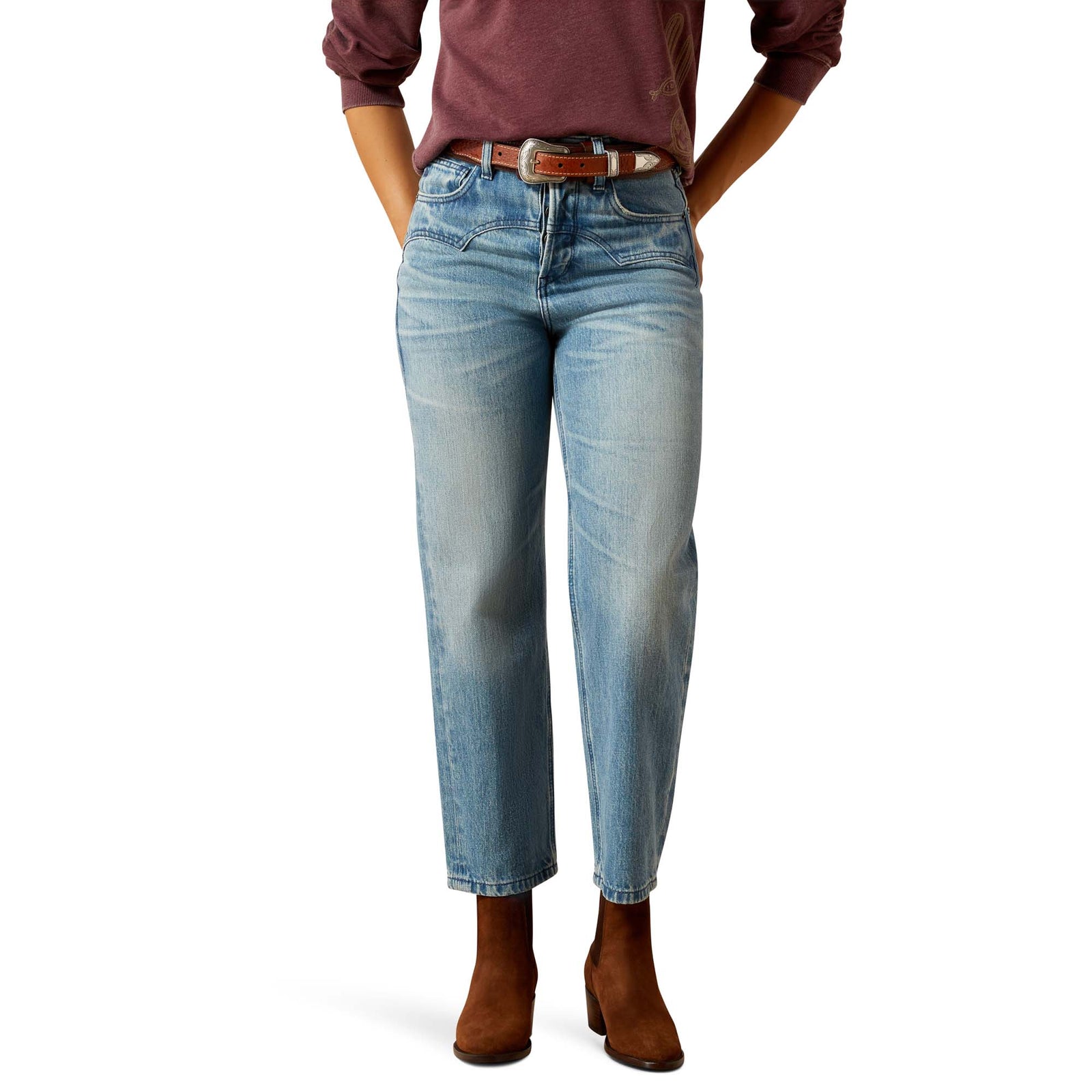 Person wearing light blue jeans and brown shoes on a white background