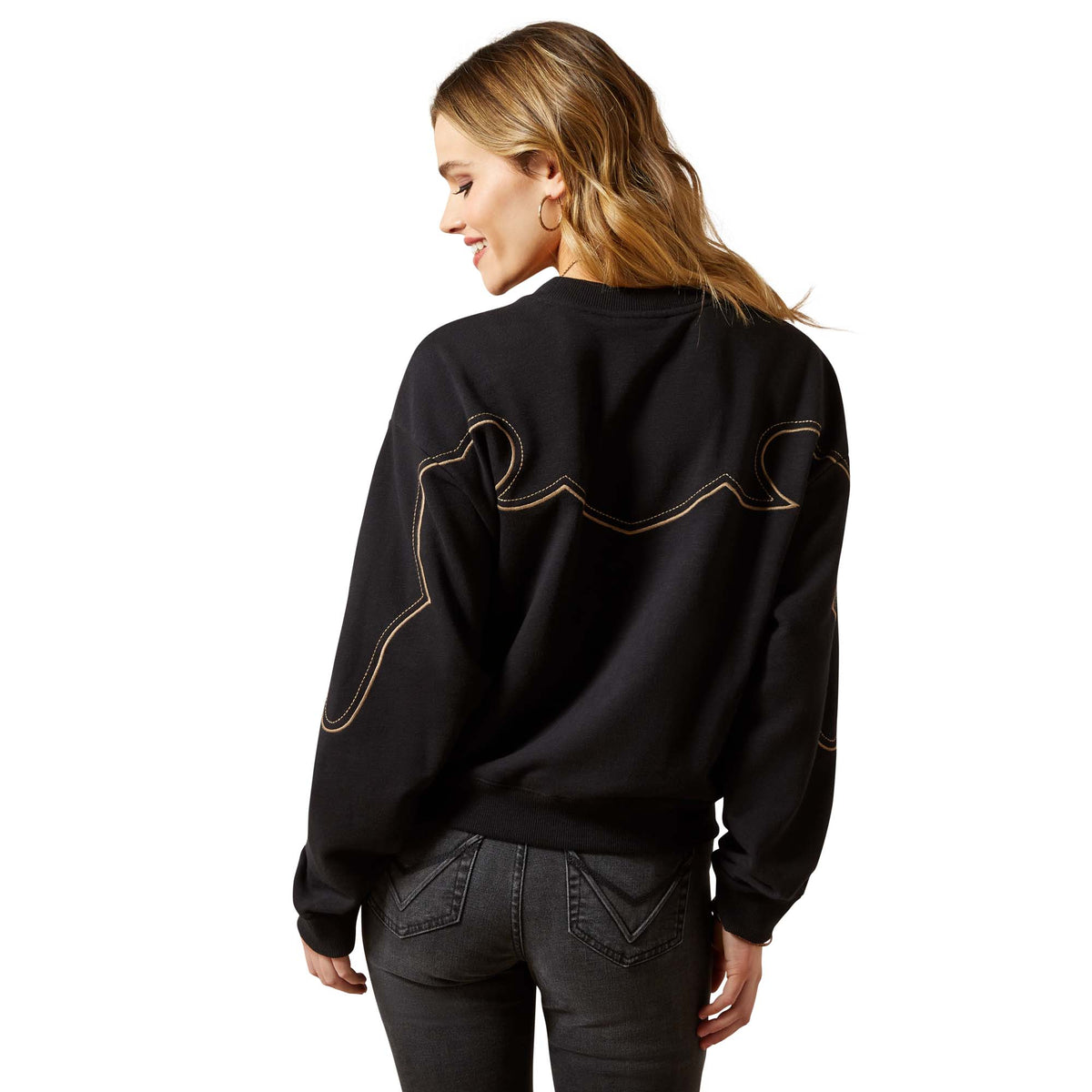 Person wearing a black sweatshirt with decorative stitching on the back, standing against a white background.
